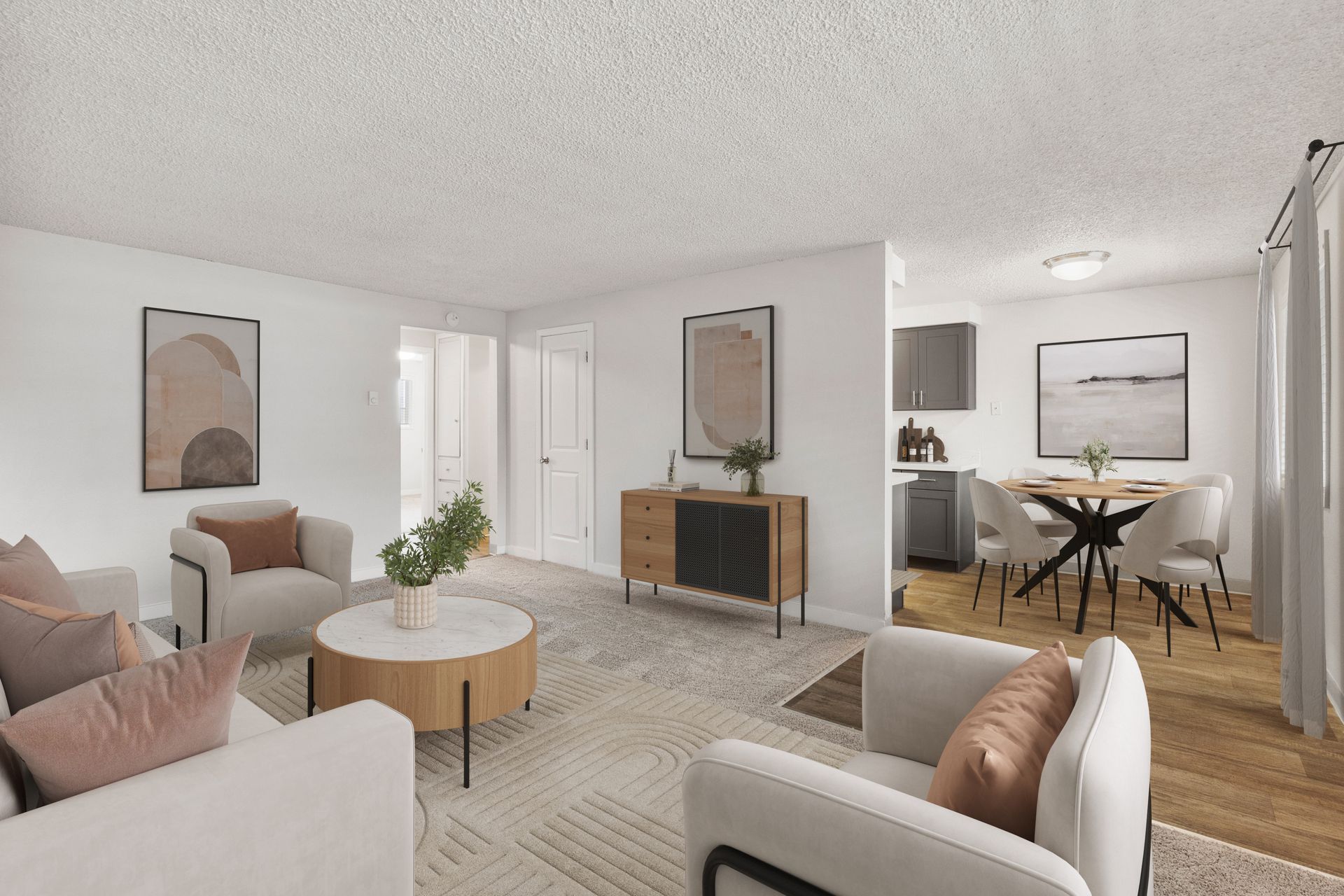 Living room with neutral tones, artwork, and a view into a dining area with a round table.