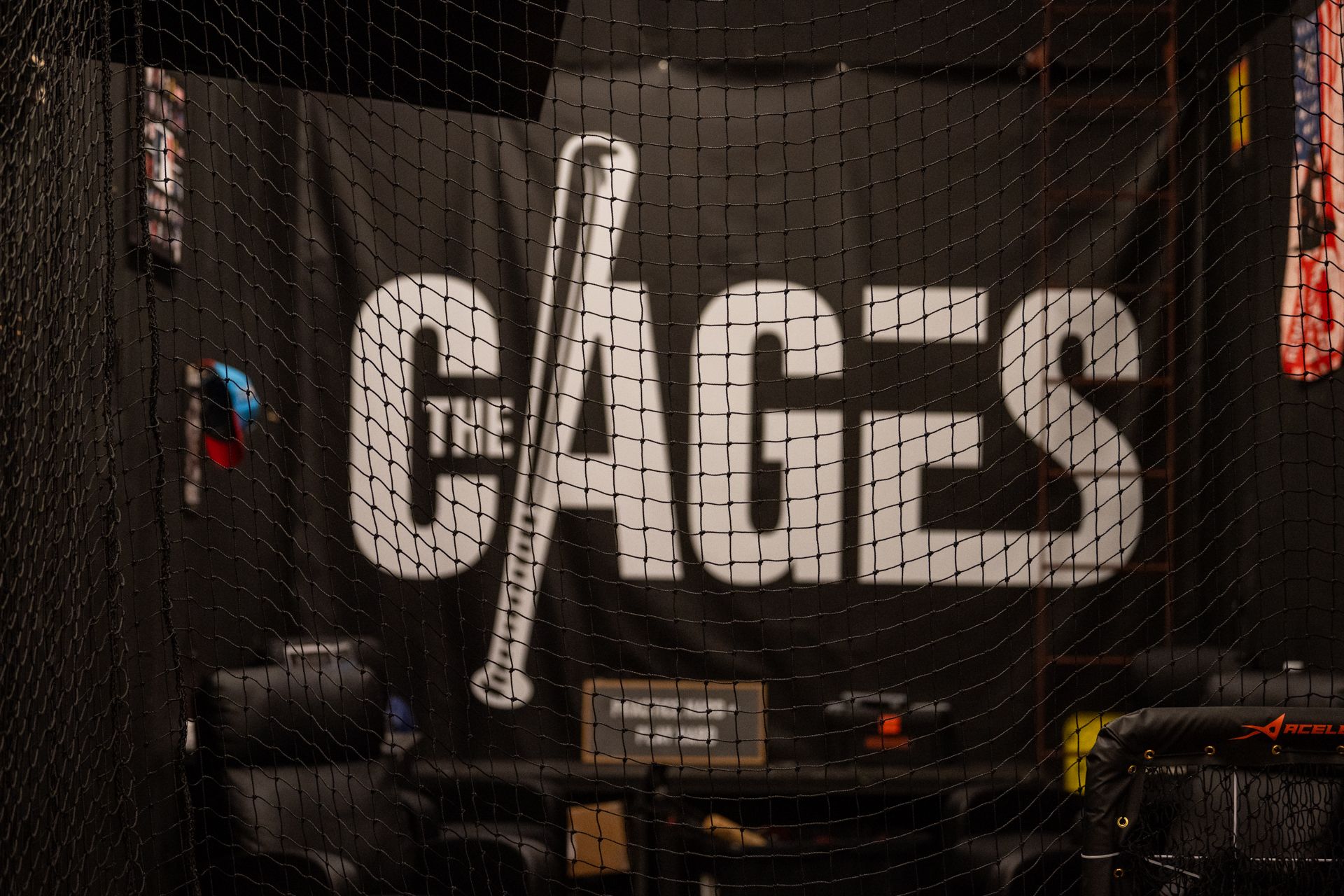 A sign that says the cages with a baseball bat on it