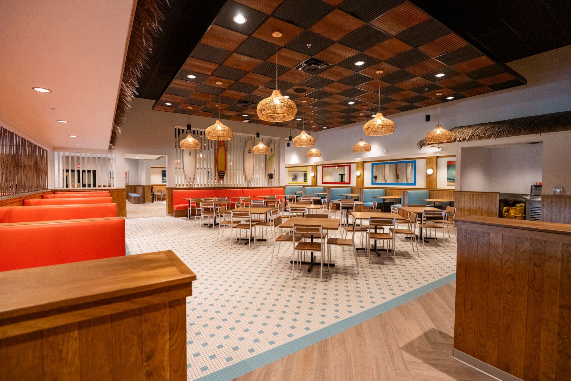 A restaurant with tables and chairs and a wooden ceiling.
