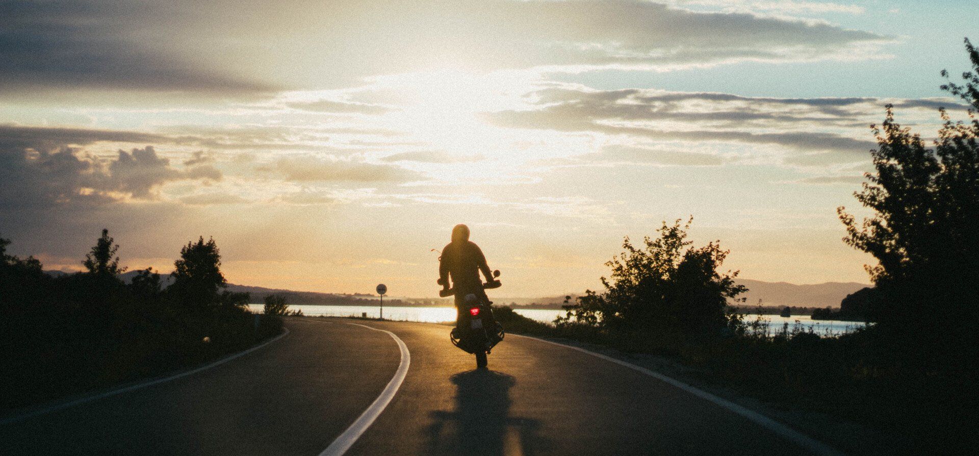 Man riding motorcycle during sunset