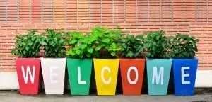 A row of colorful potted plants spelling out the word welcome.