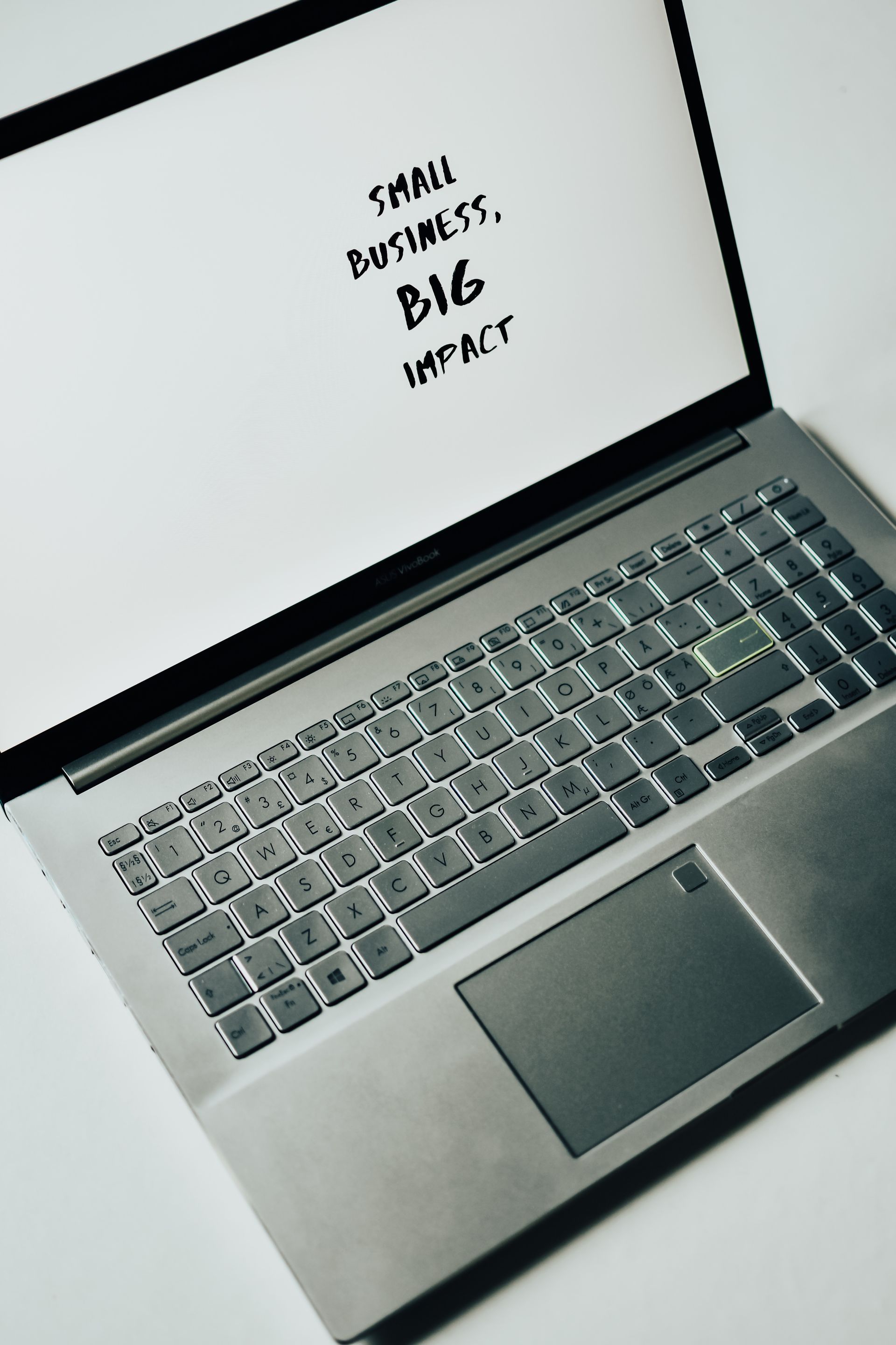 a laptop with the words small business big impact on the screen