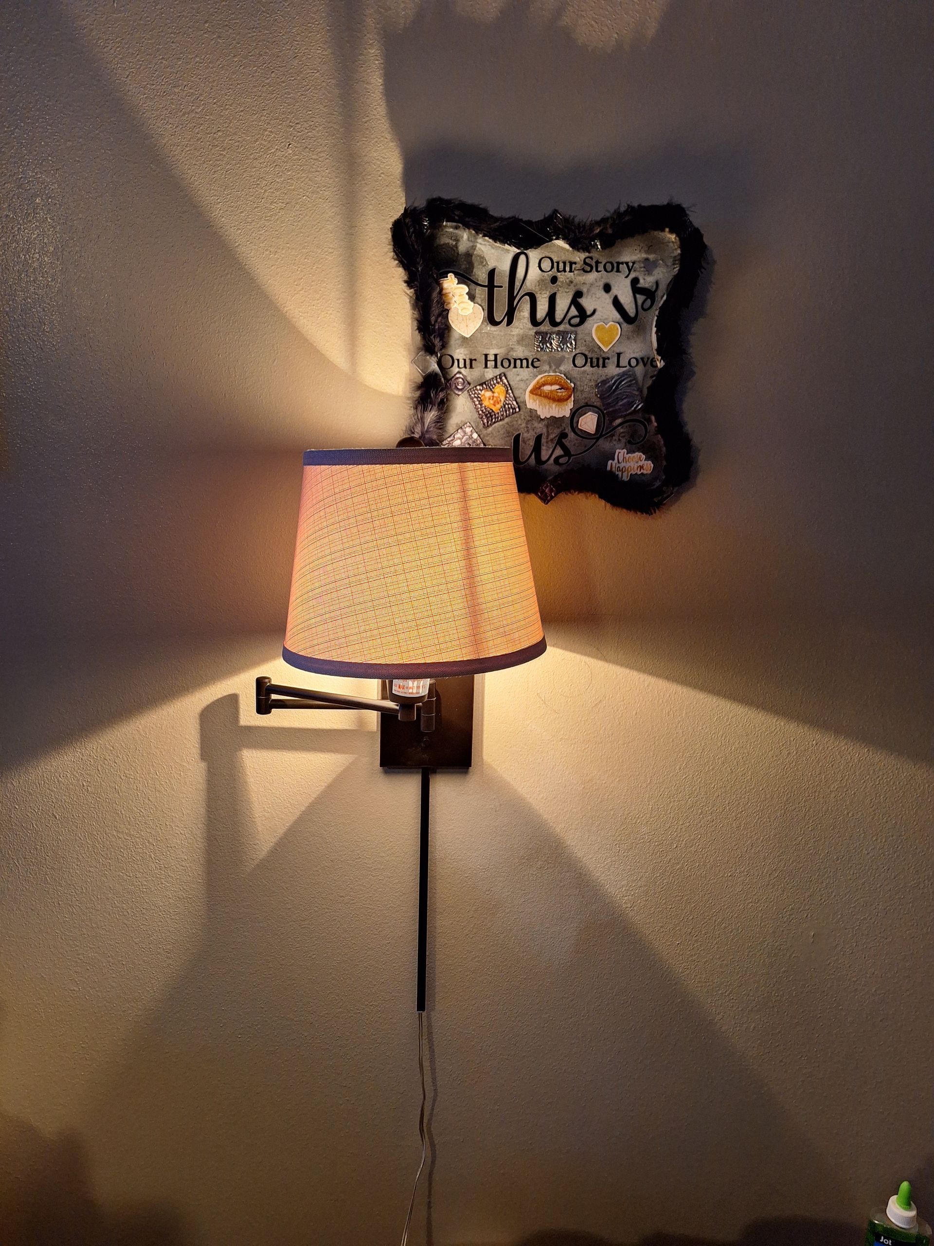 A lamp with a pillow on the wall above it.