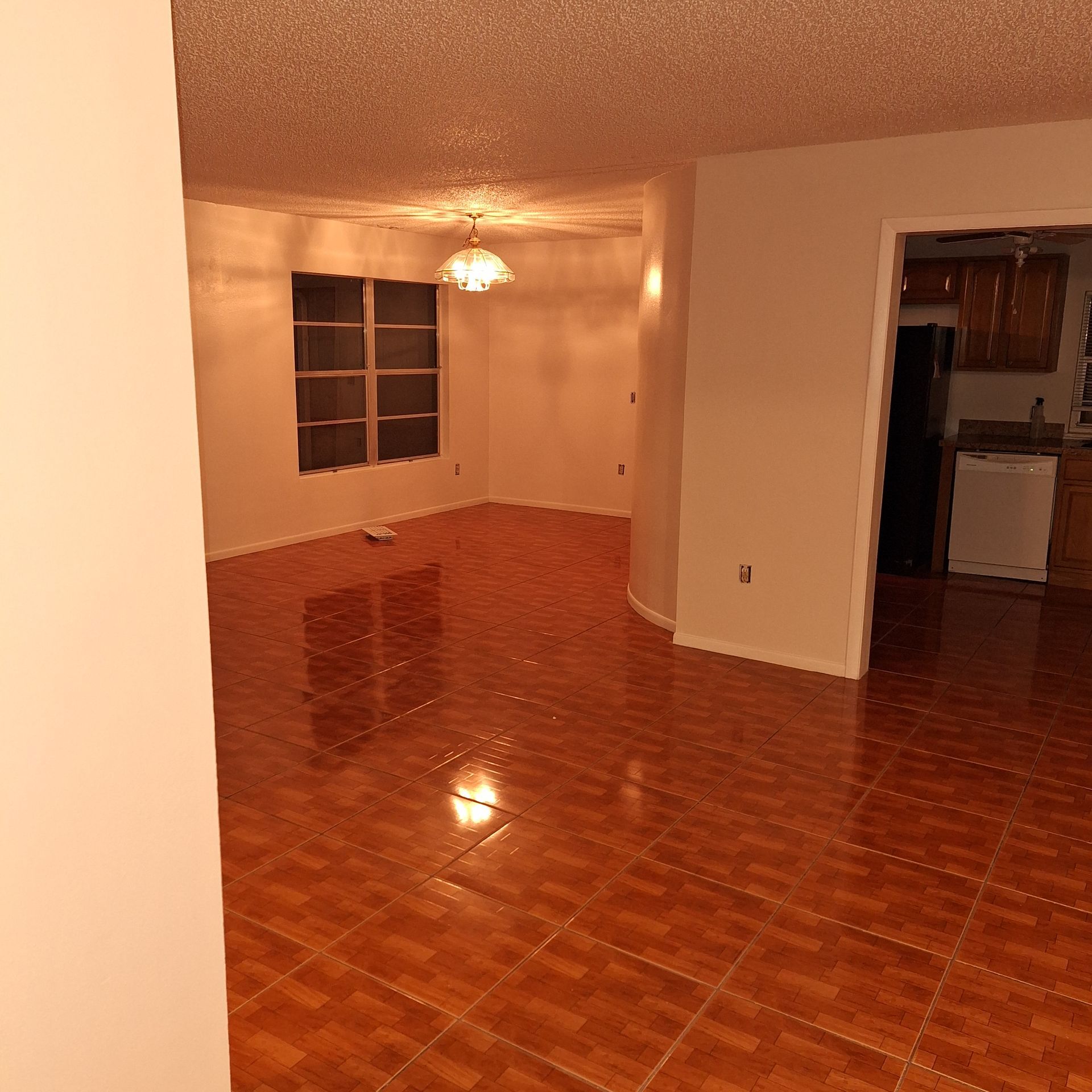 An empty room with a tiled floor and a window