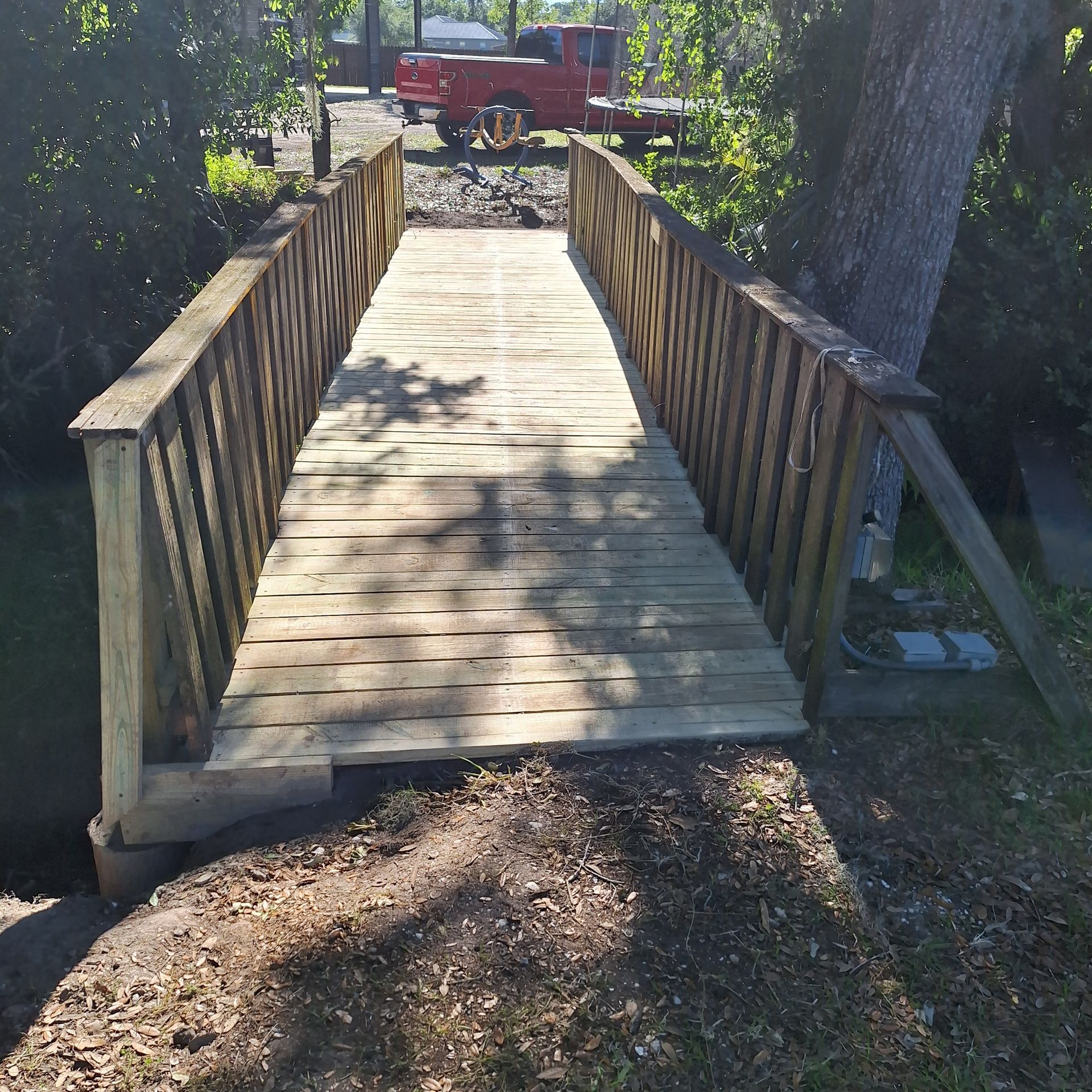 A wooden bridge with a red truck in the background