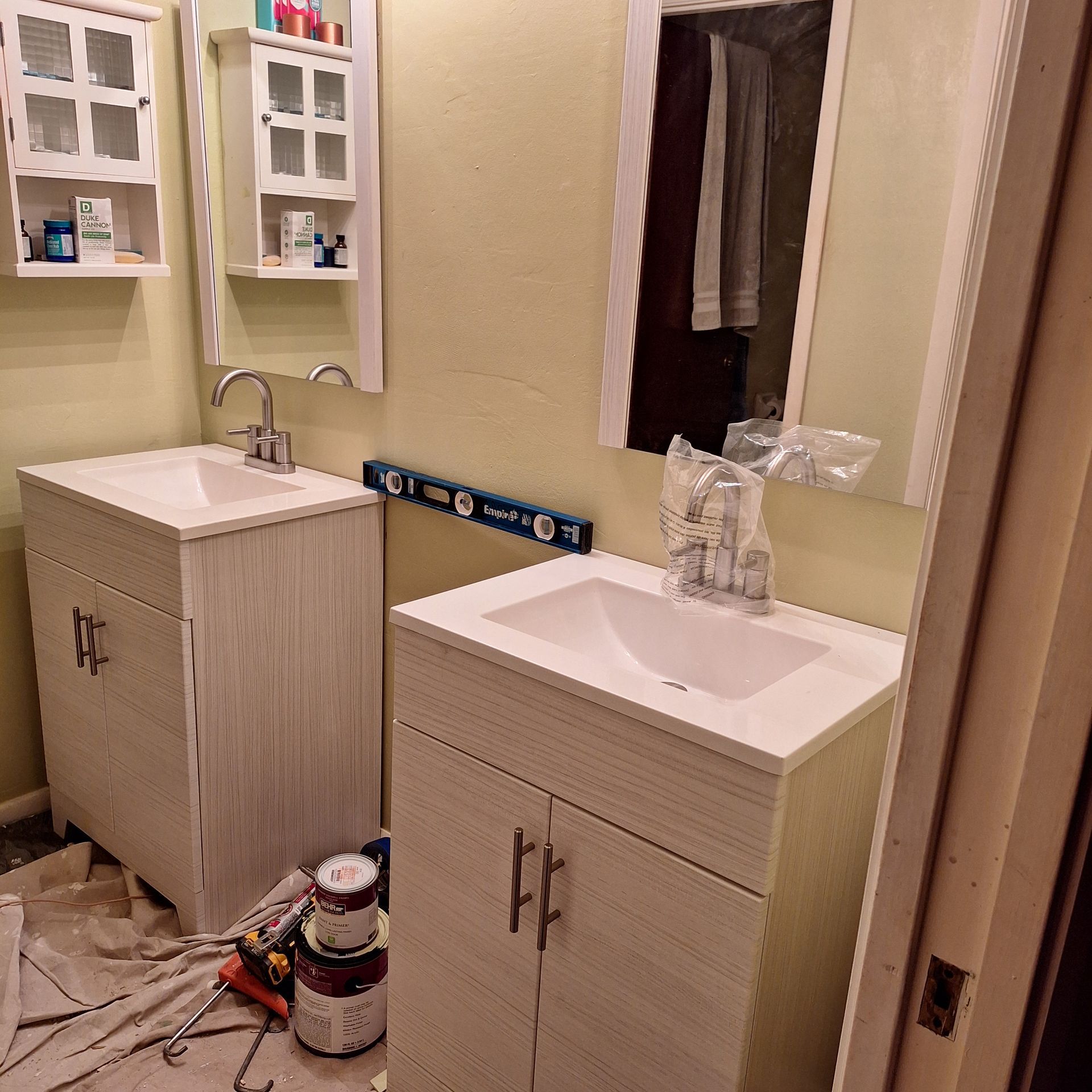 A bathroom with two sinks and a level on the wall