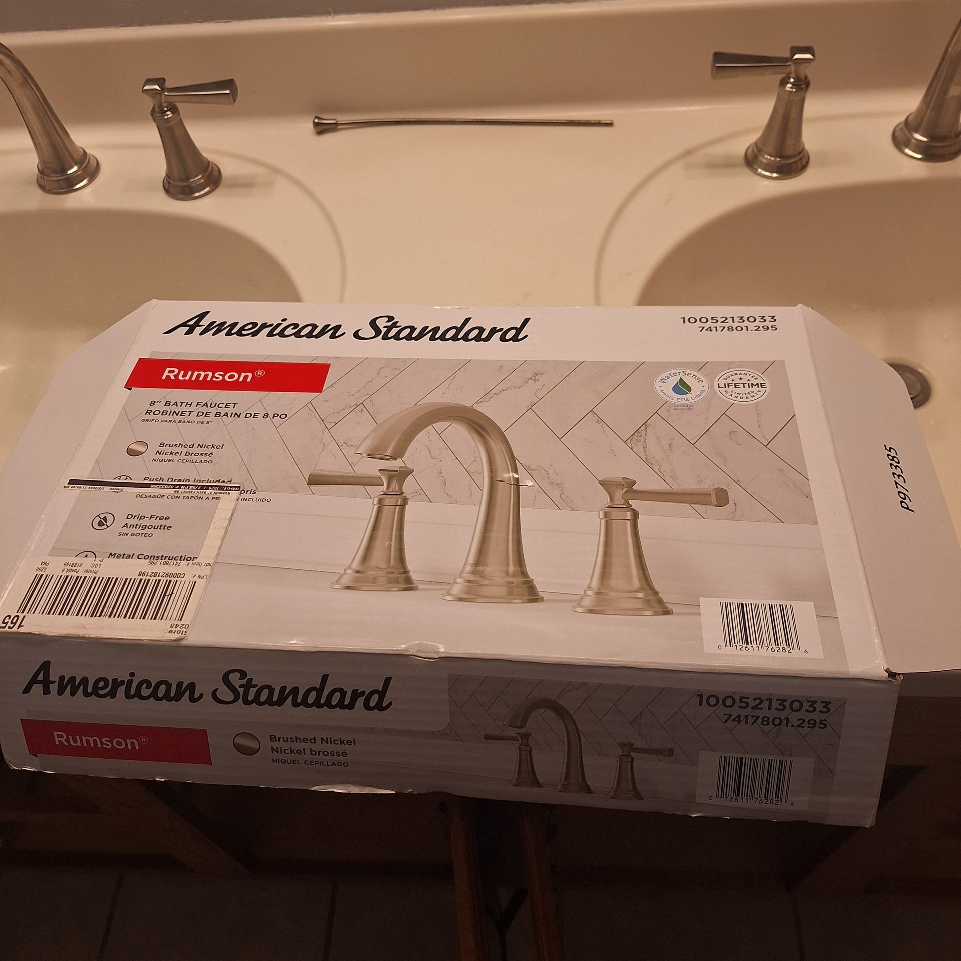 A box of american standard faucets sits in front of two sinks