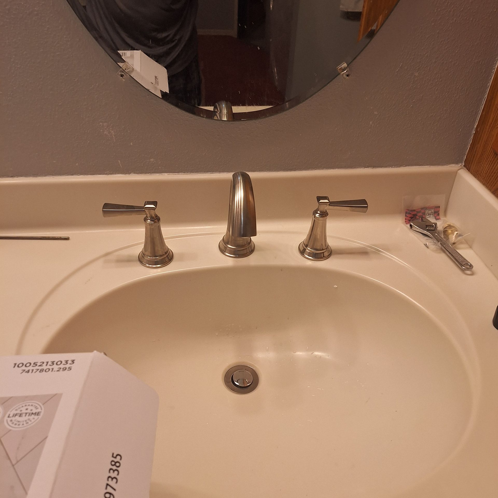 A bathroom sink with a box that says 972385 on it
