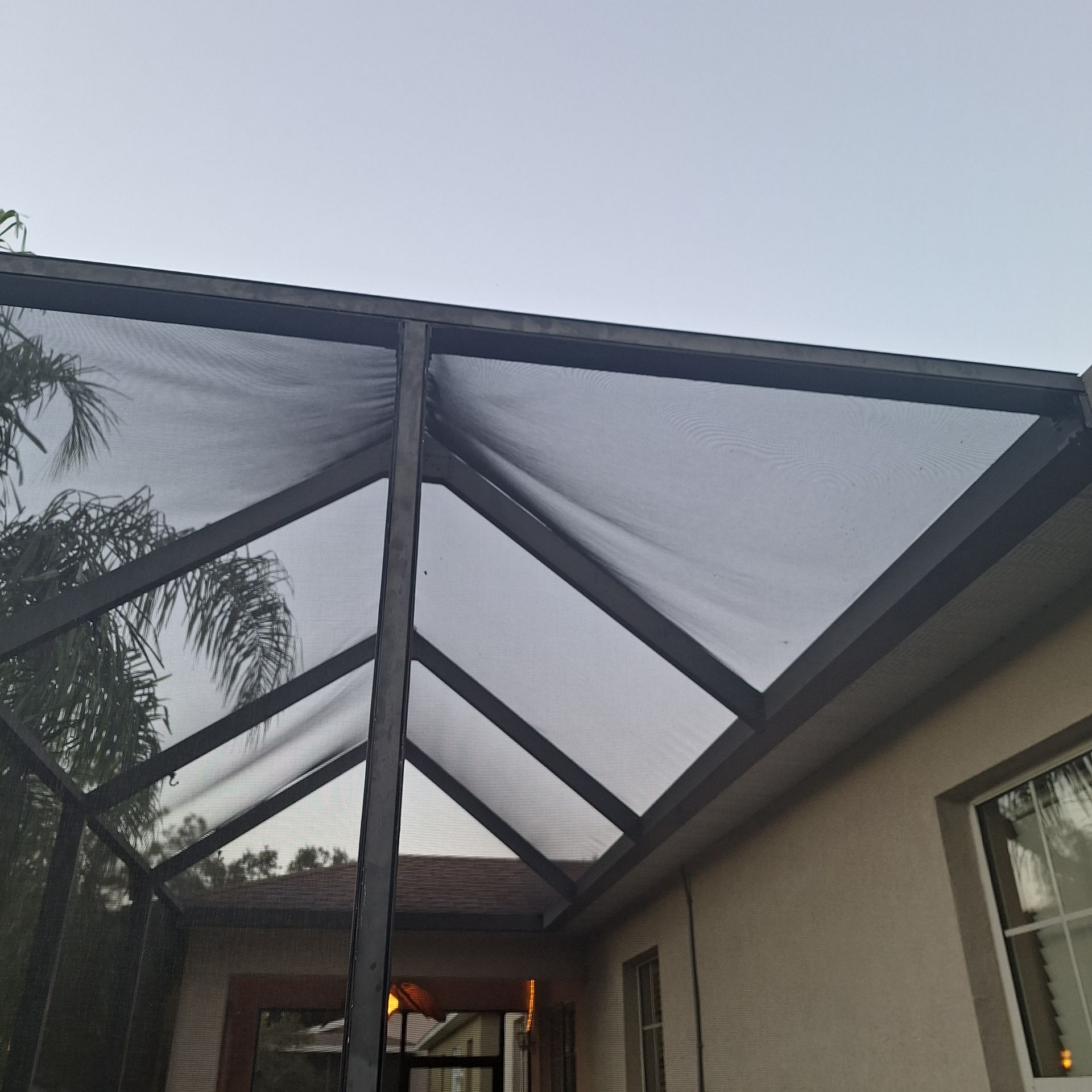 A house with a screened in porch and a clear roof