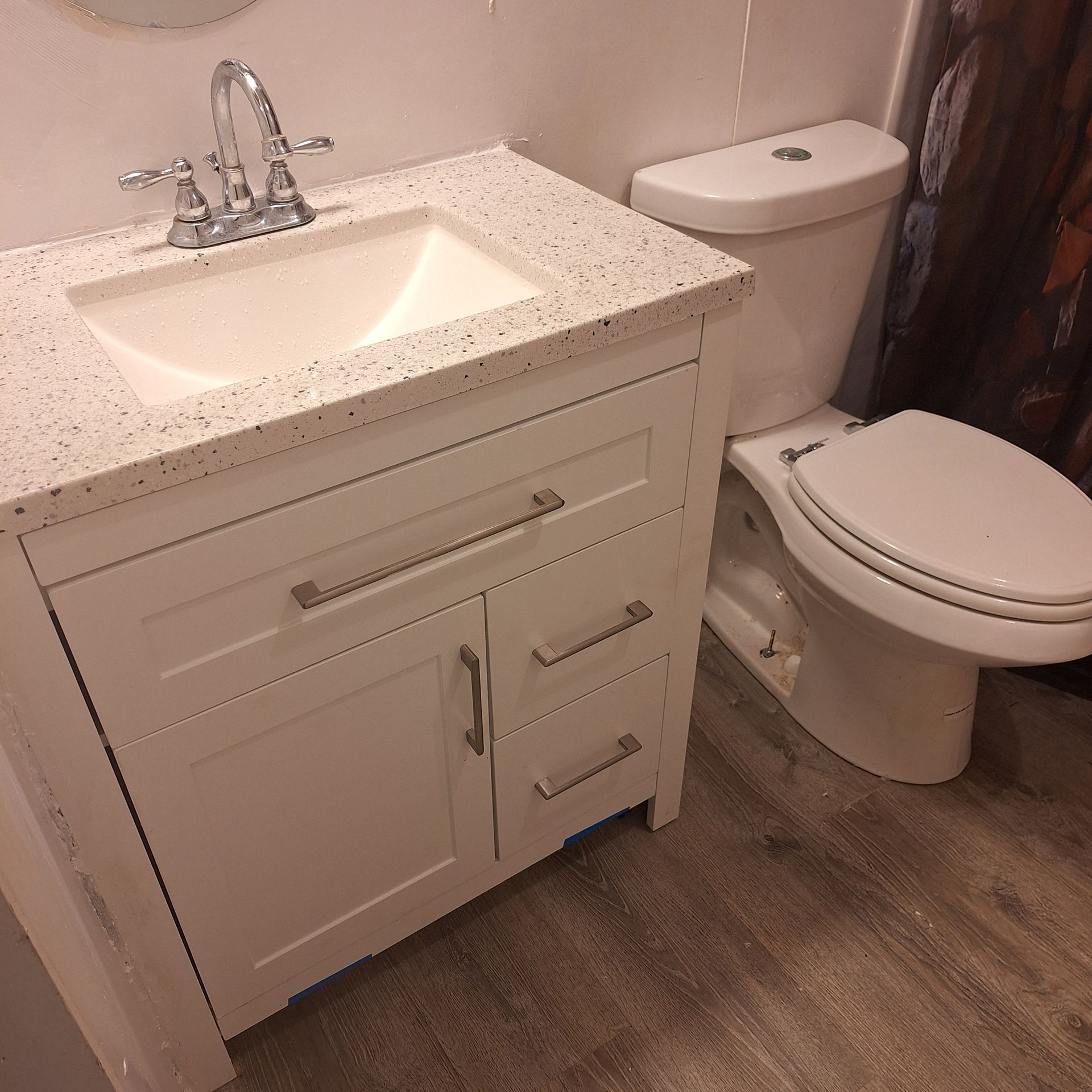 A bathroom with a sink , toilet and mirror.