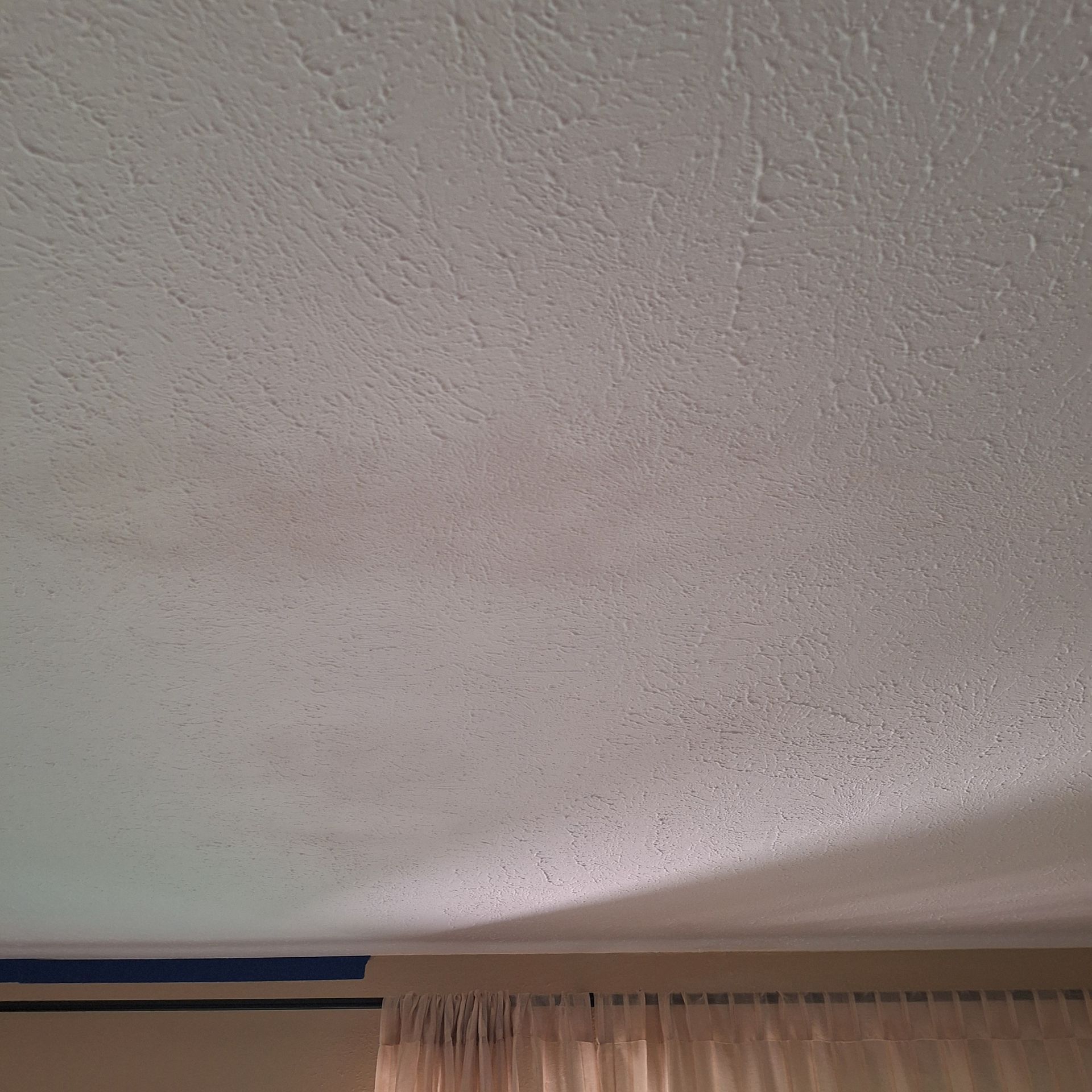 A close up of a white ceiling in a living room.