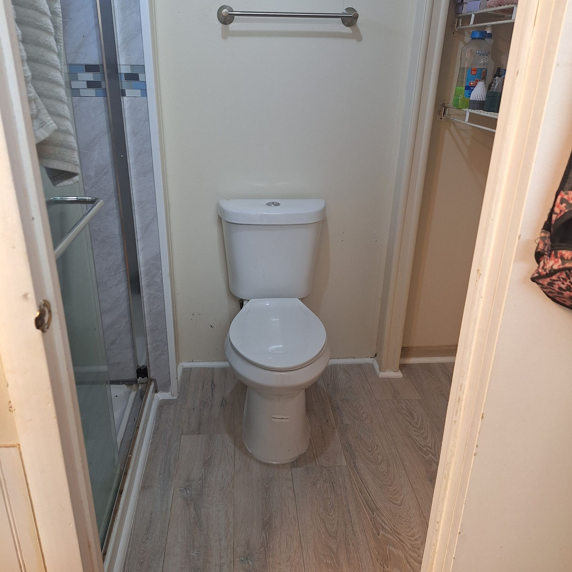 A toilet in a bathroom next to a shower