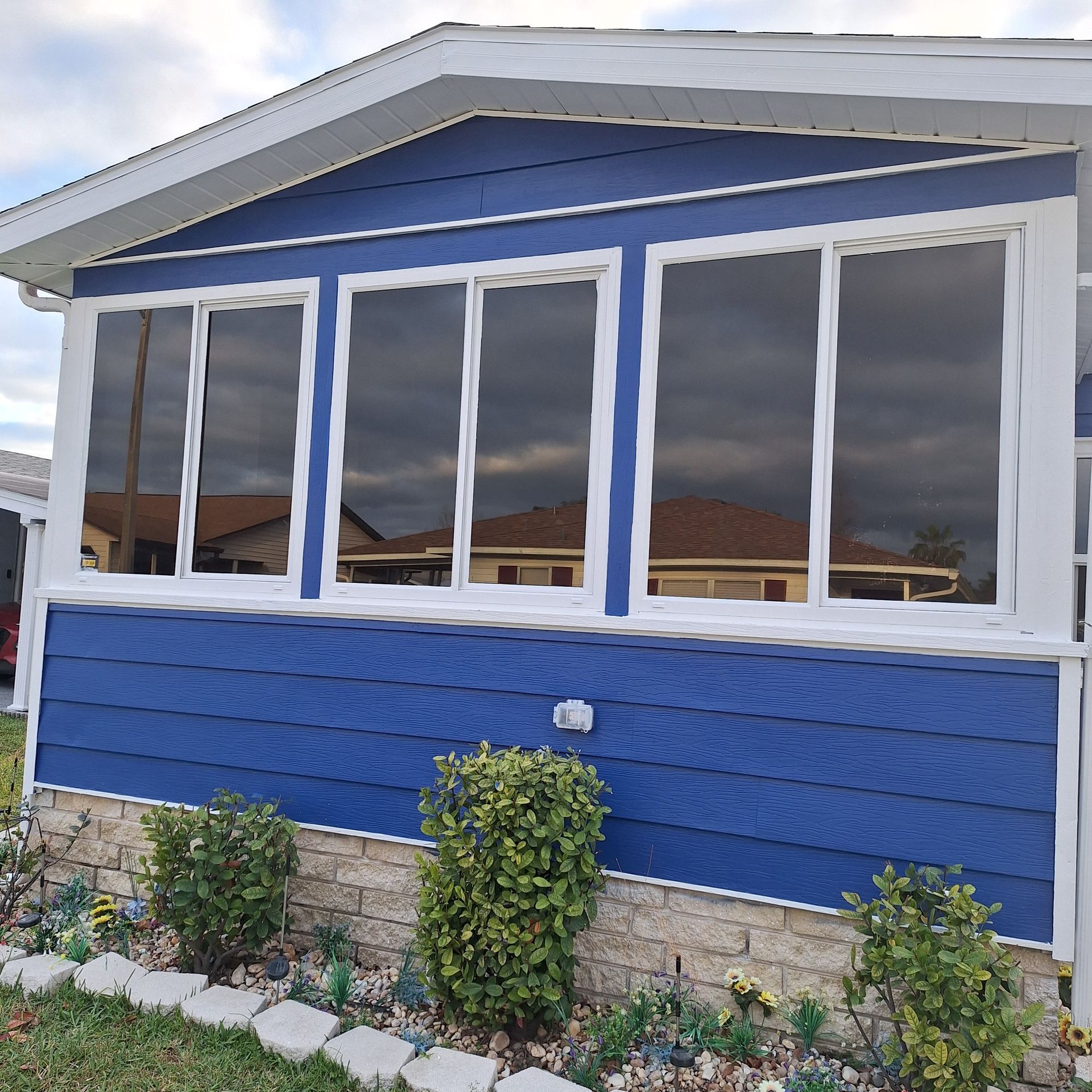 A blue house with white trim and a lot of windows