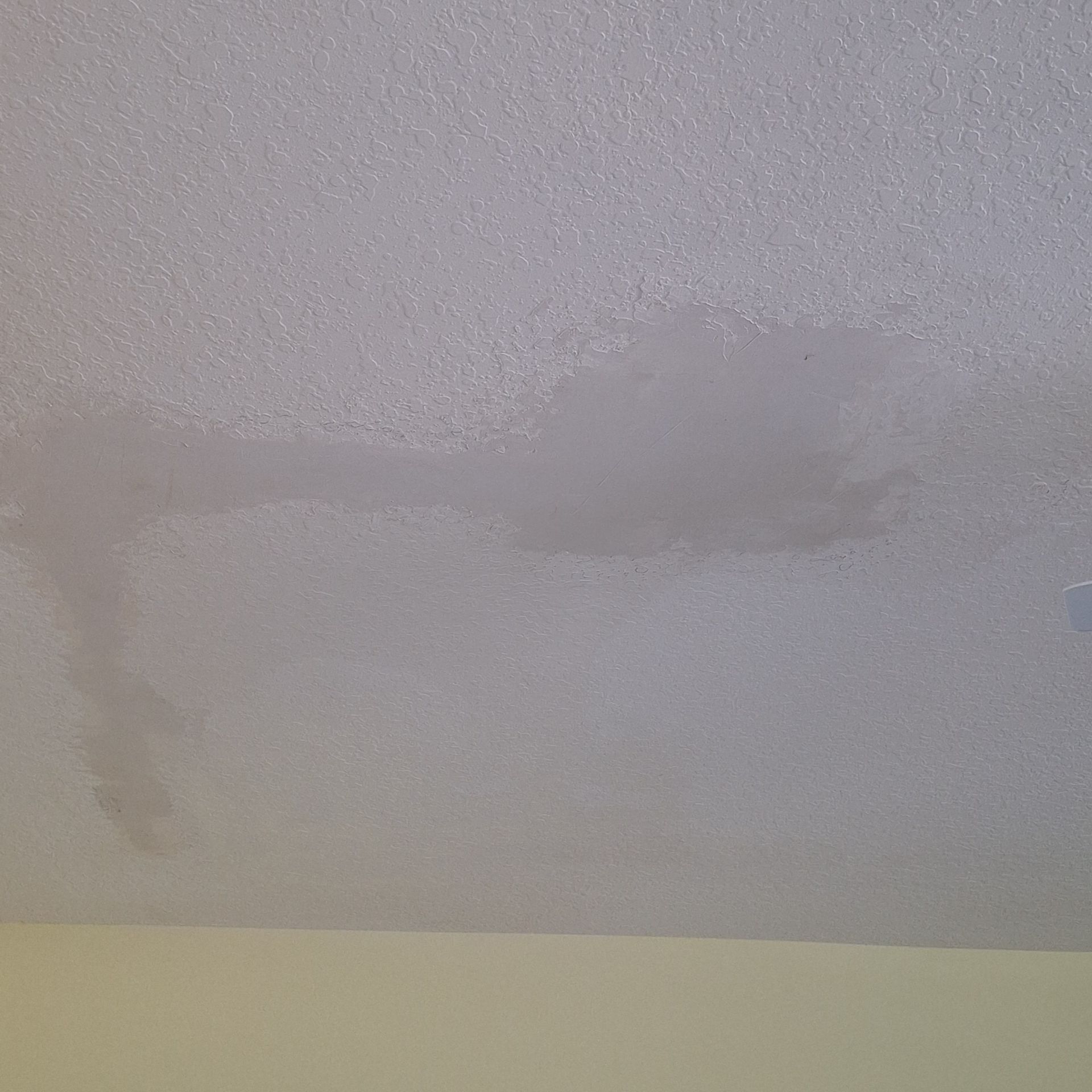A close up of a white ceiling with a stain on it.