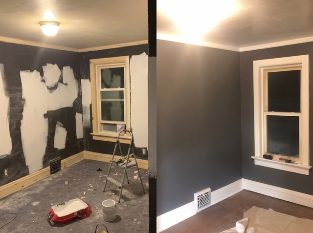 Partially renovated room with dark gray walls, patched drywall, and painting supplies near two windows
