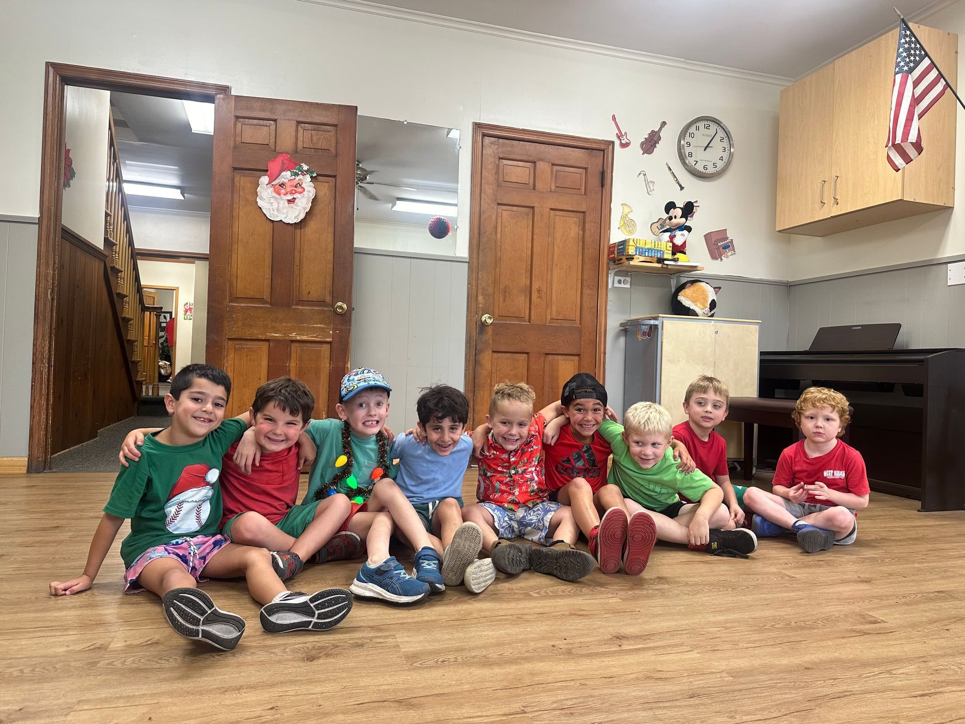 A group of children are sitting on the floor in a room.