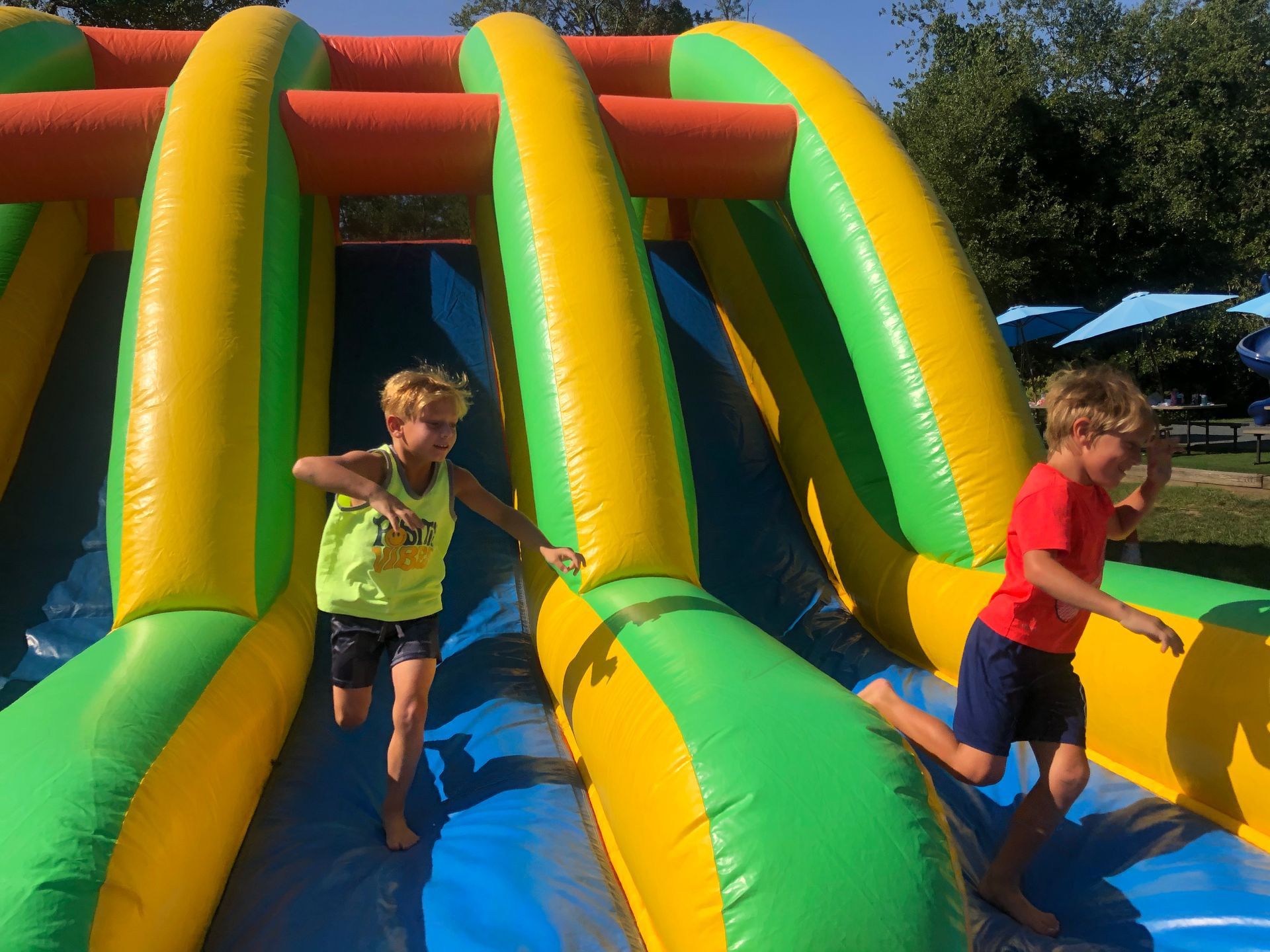 Two young boys are playing on an inflatable obstacle course.