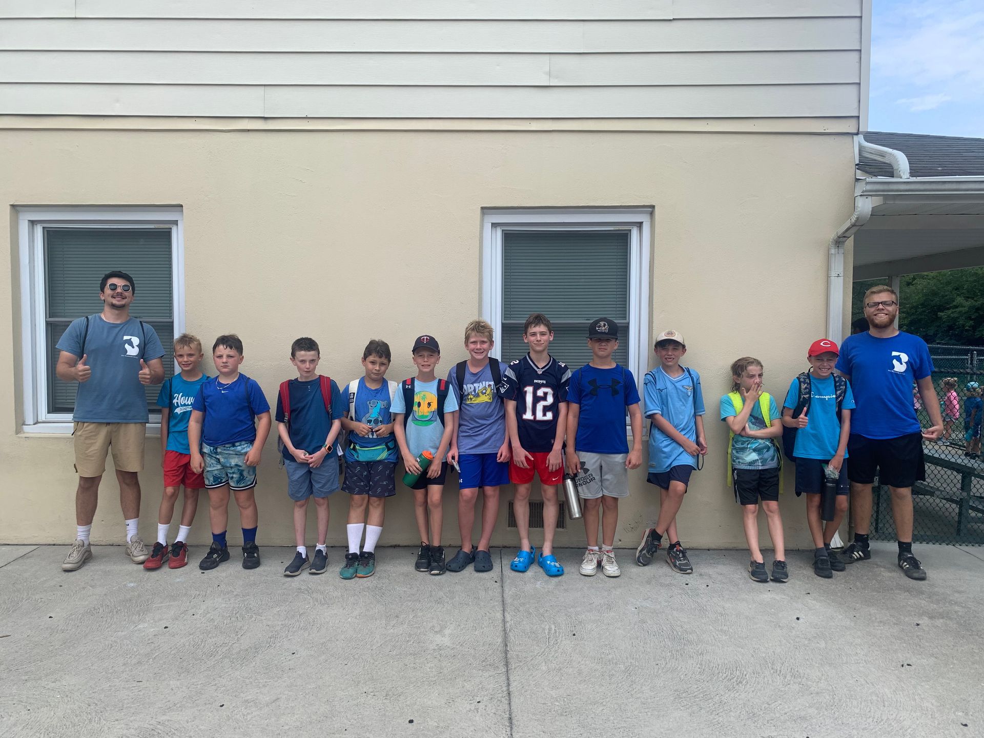 A group of young boys are standing in front of a building.