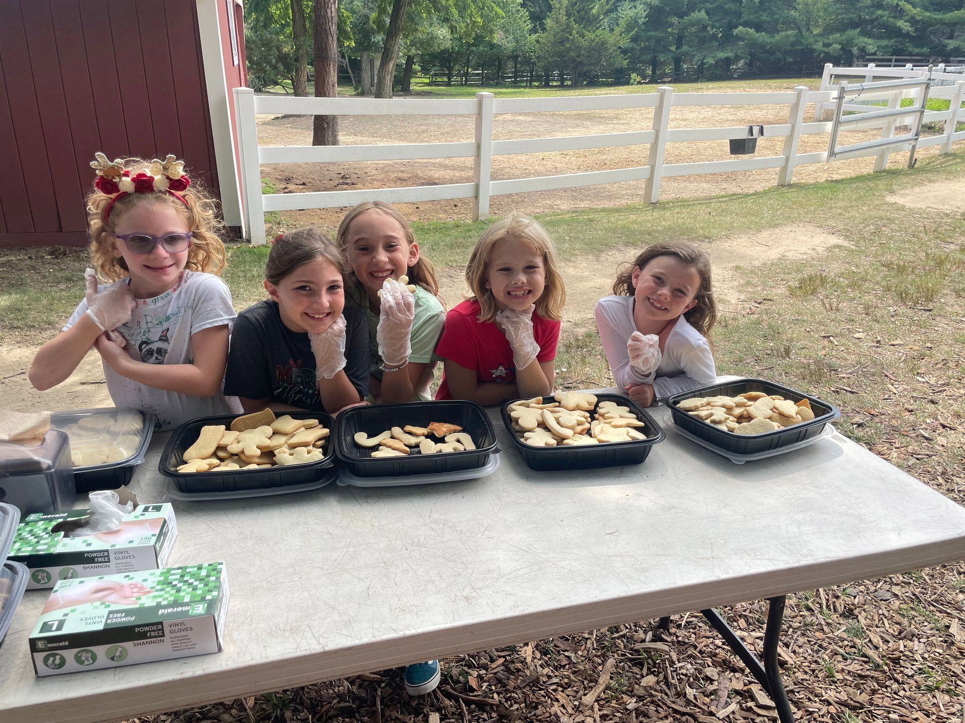 A group of young girls are sitting at a table with trays of food.