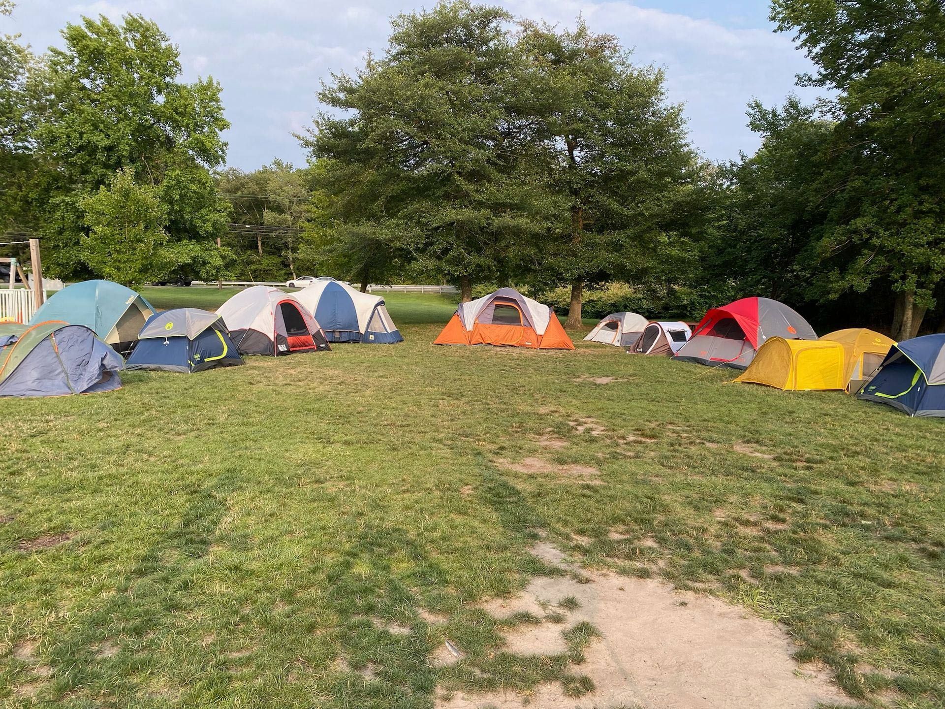 A group of tents are sitting in a grassy field.