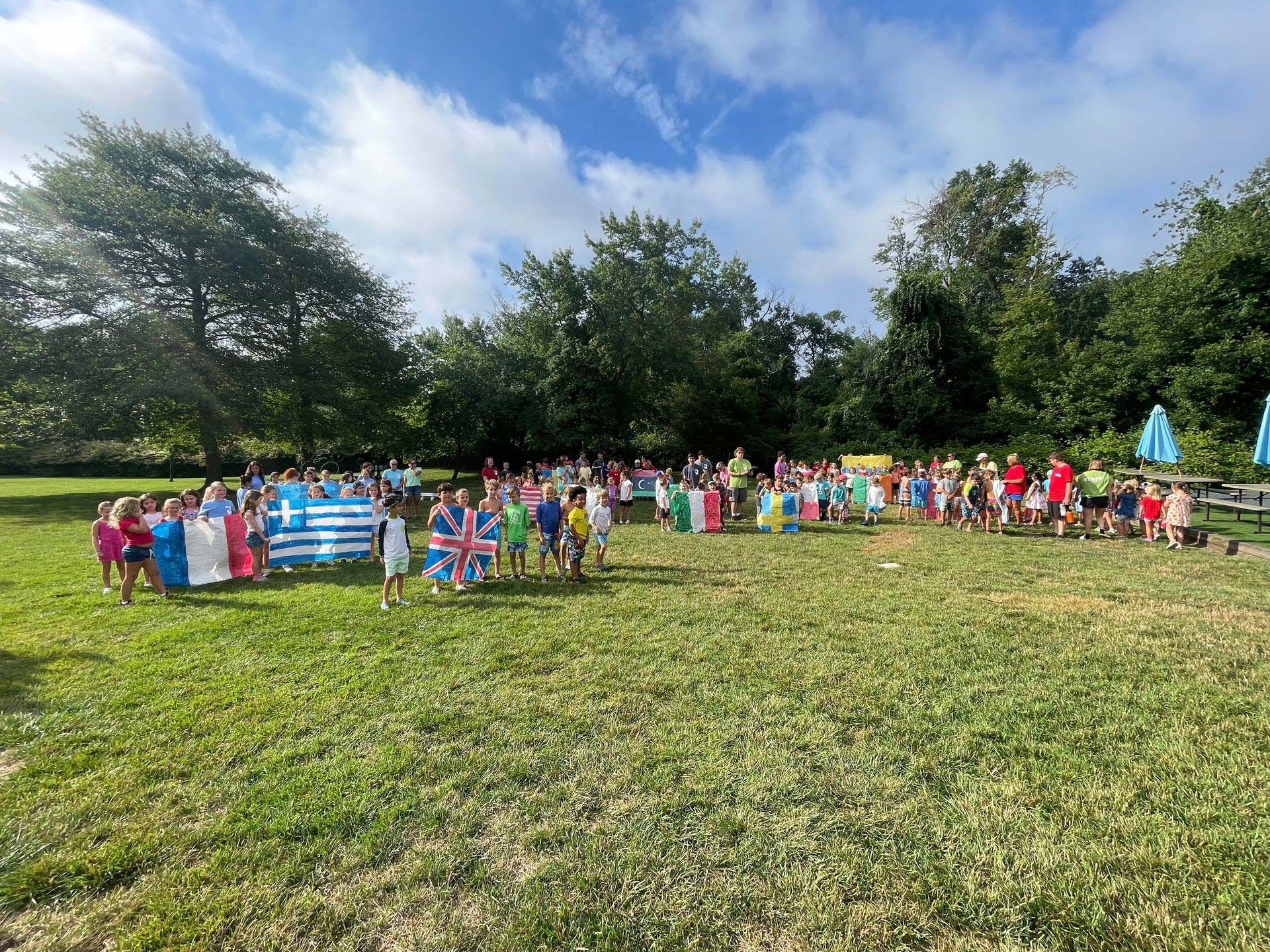 A group of people are standing in a field with flags from different countries.