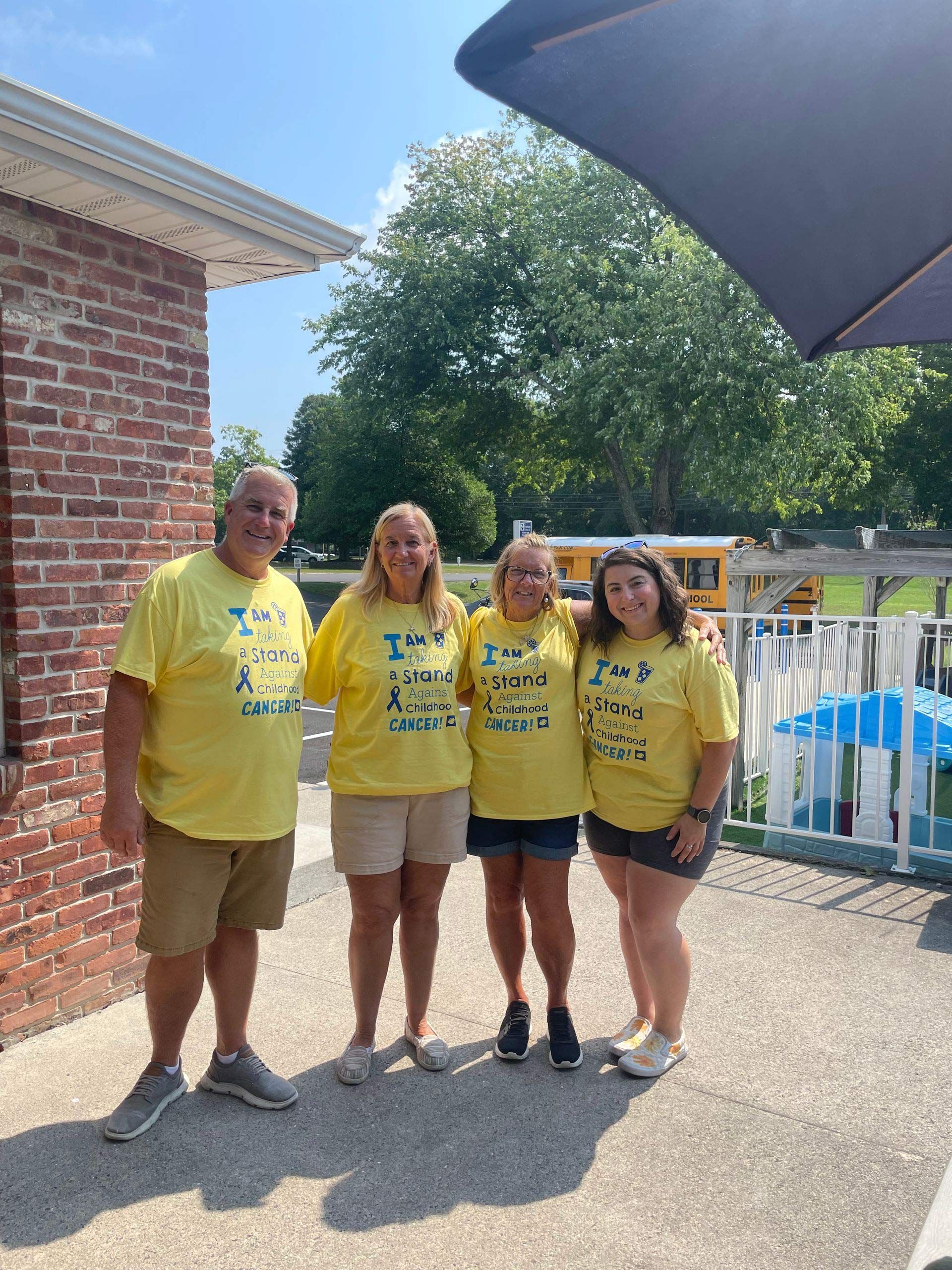 A group of people wearing yellow shirts are posing for a picture.