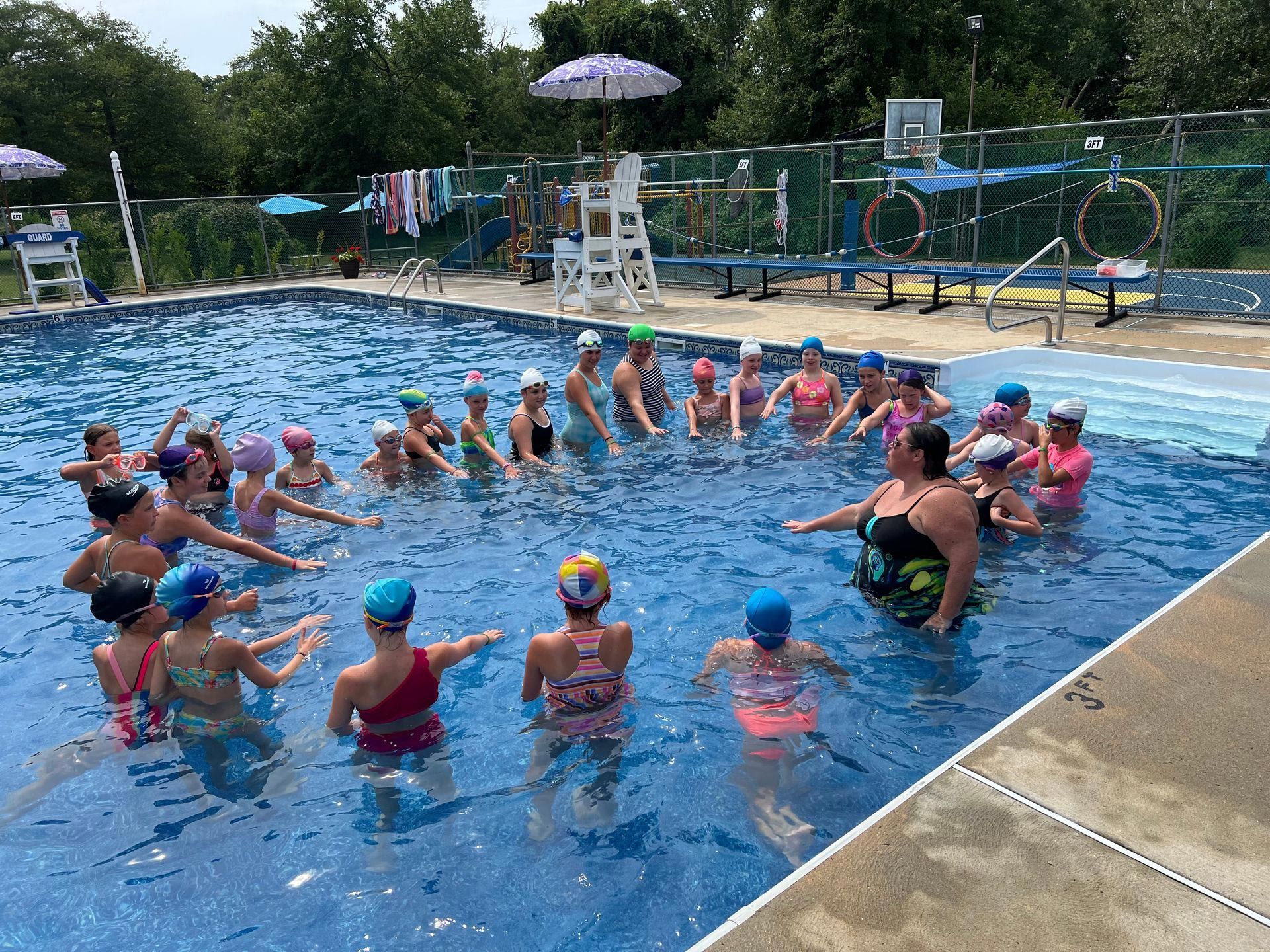 A group of people are standing in a swimming pool.