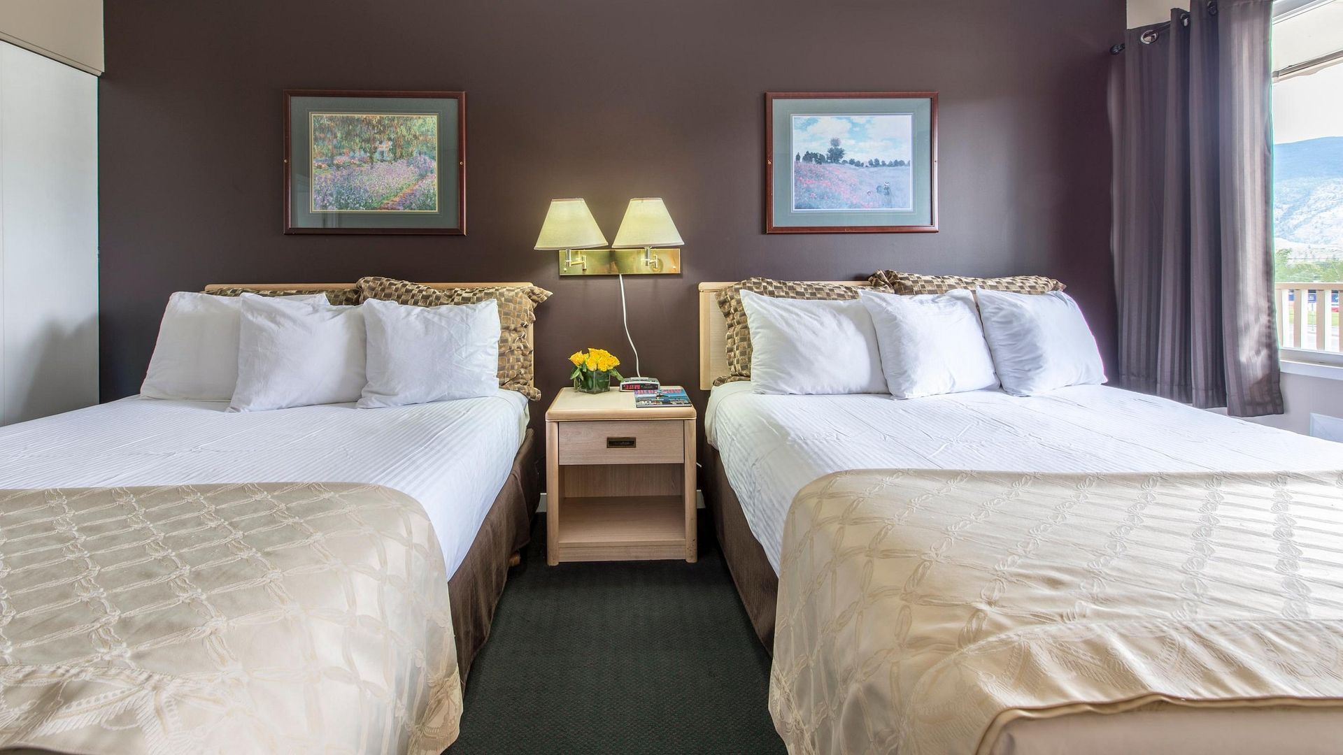 A hotel room with two beds and two lamps