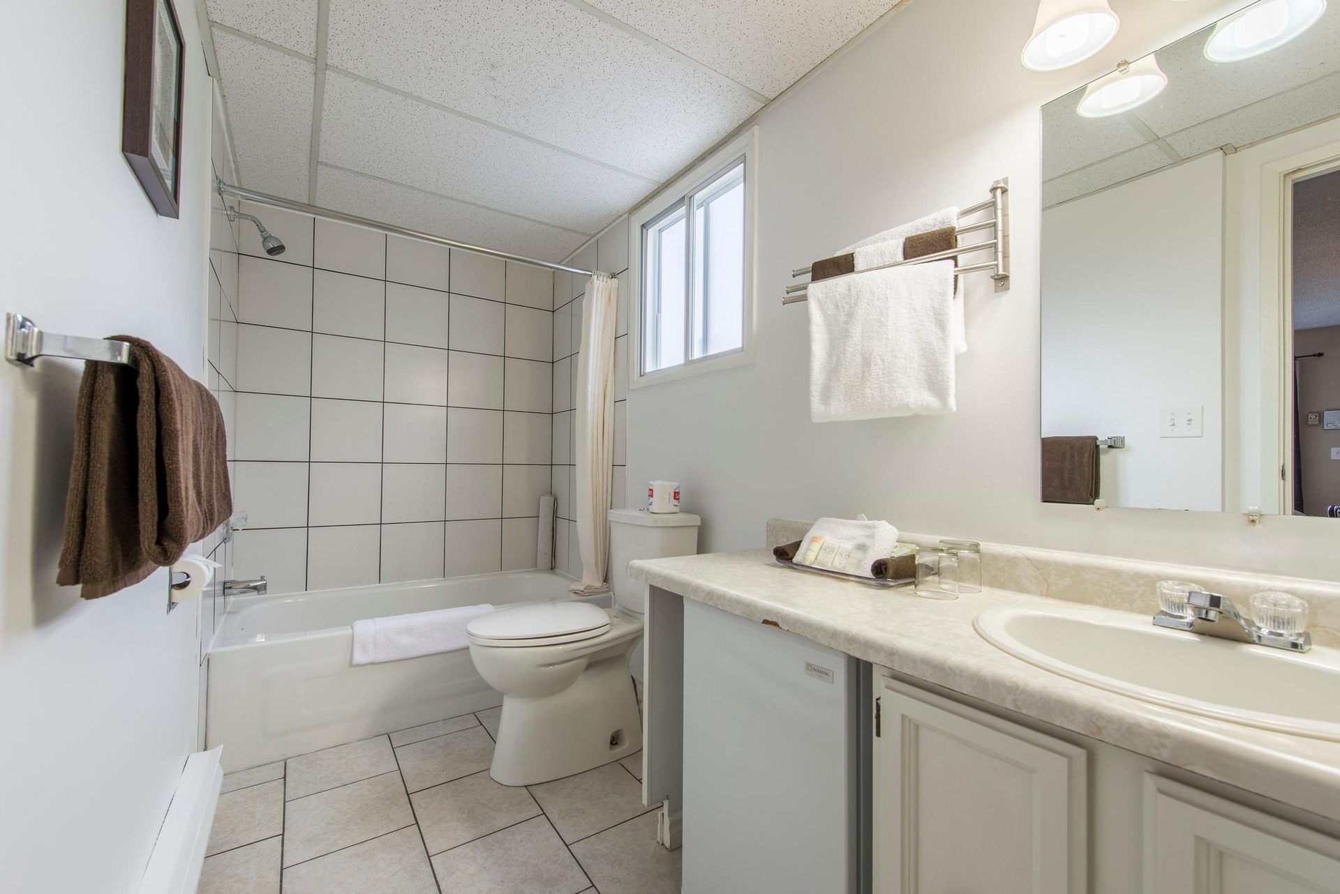 A bathroom with a sink , toilet , bathtub and mirror