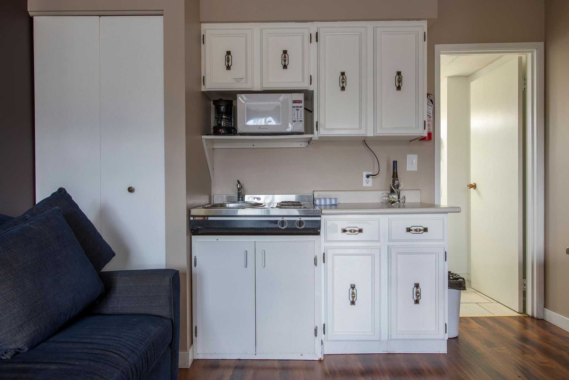 A small kitchen with white cabinets and a microwave