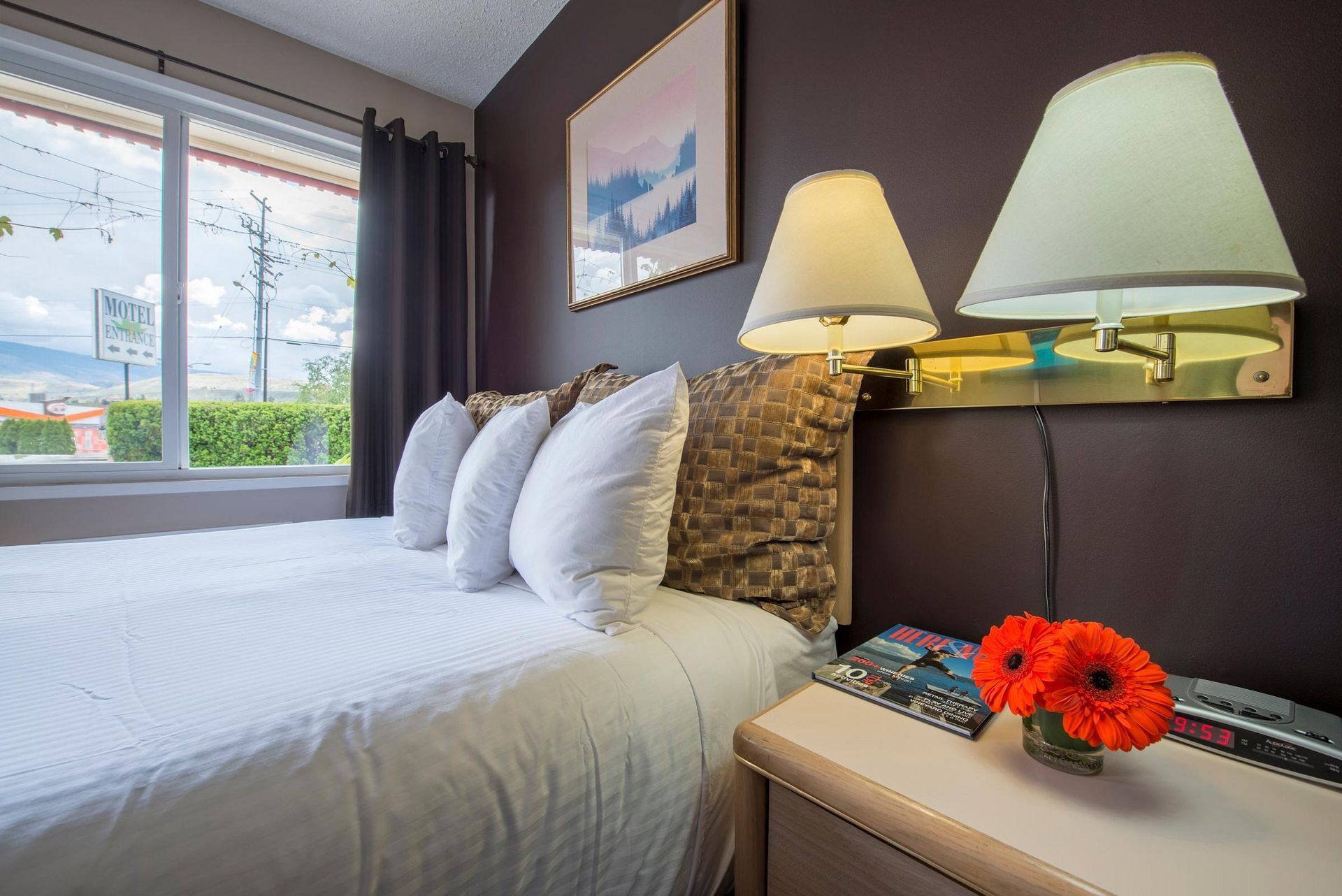 A hotel room with a bed and two lamps