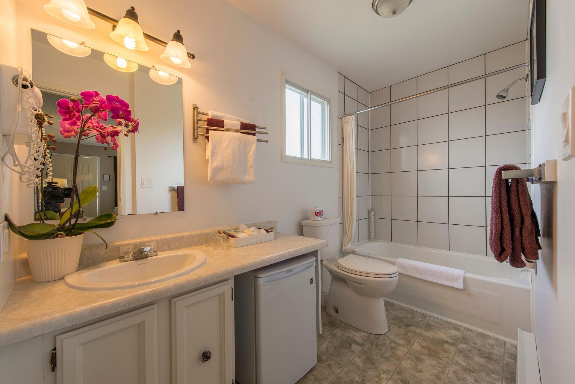 A bathroom with a sink , toilet , tub and mirror.