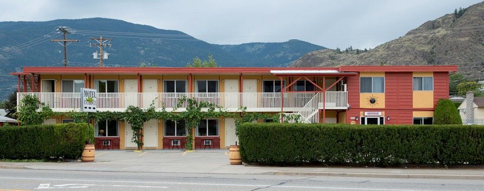 A large red and yellow building with mountains in the background.