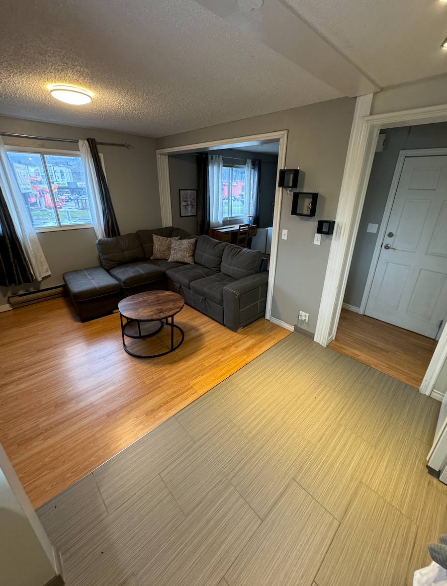 A living room with a couch , coffee table , and ottoman.