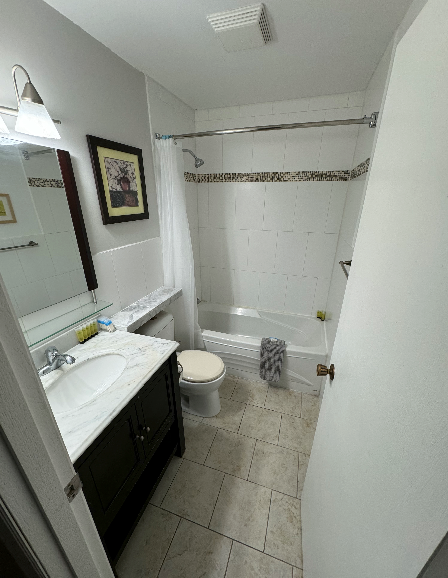 A bathroom with a sink , toilet , bathtub and mirror.