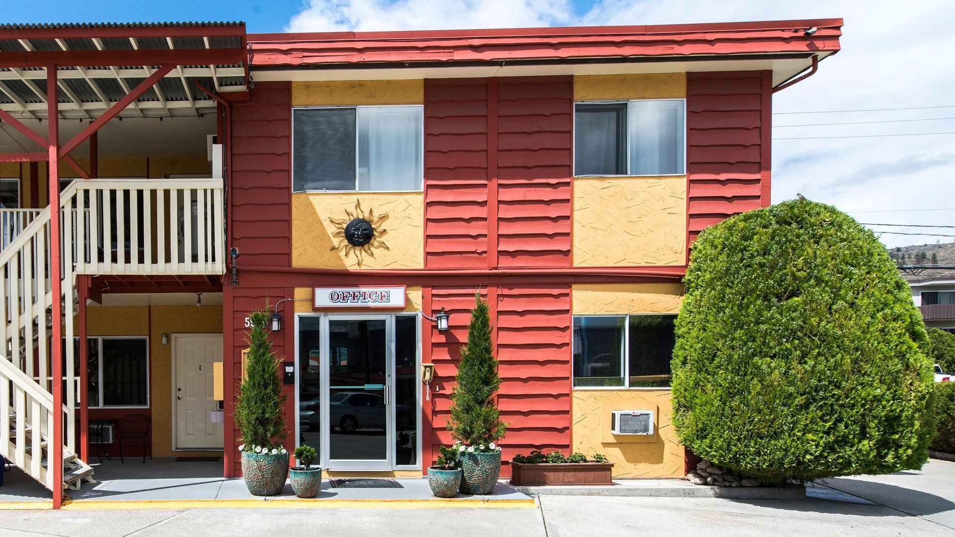 A red and yellow building with a sun on the front of it