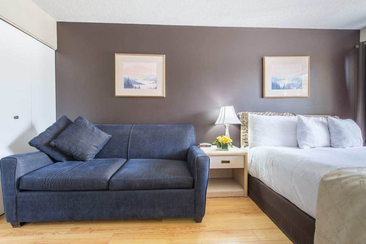 A hotel room with a couch and a bed