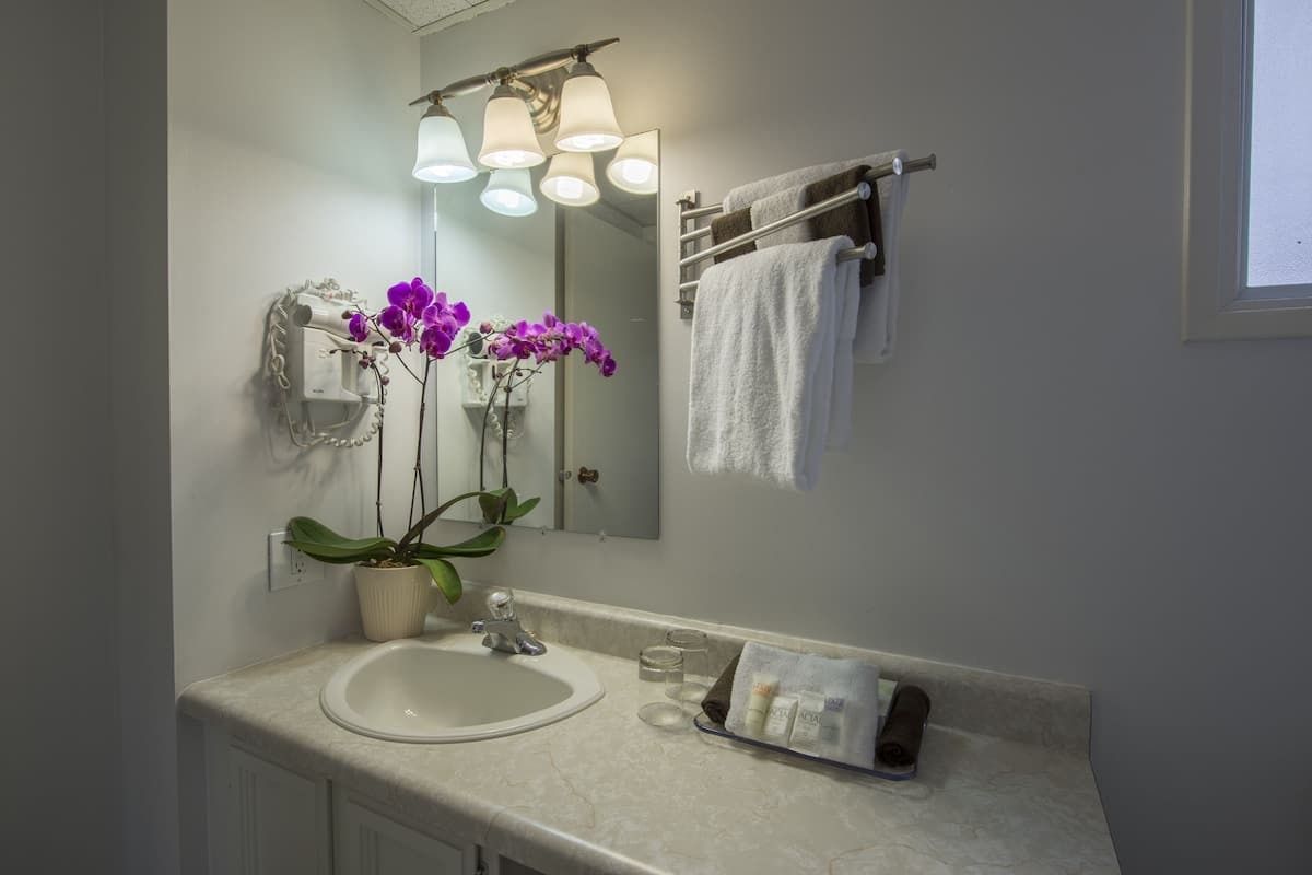 A bathroom with a sink , mirror , and towels.