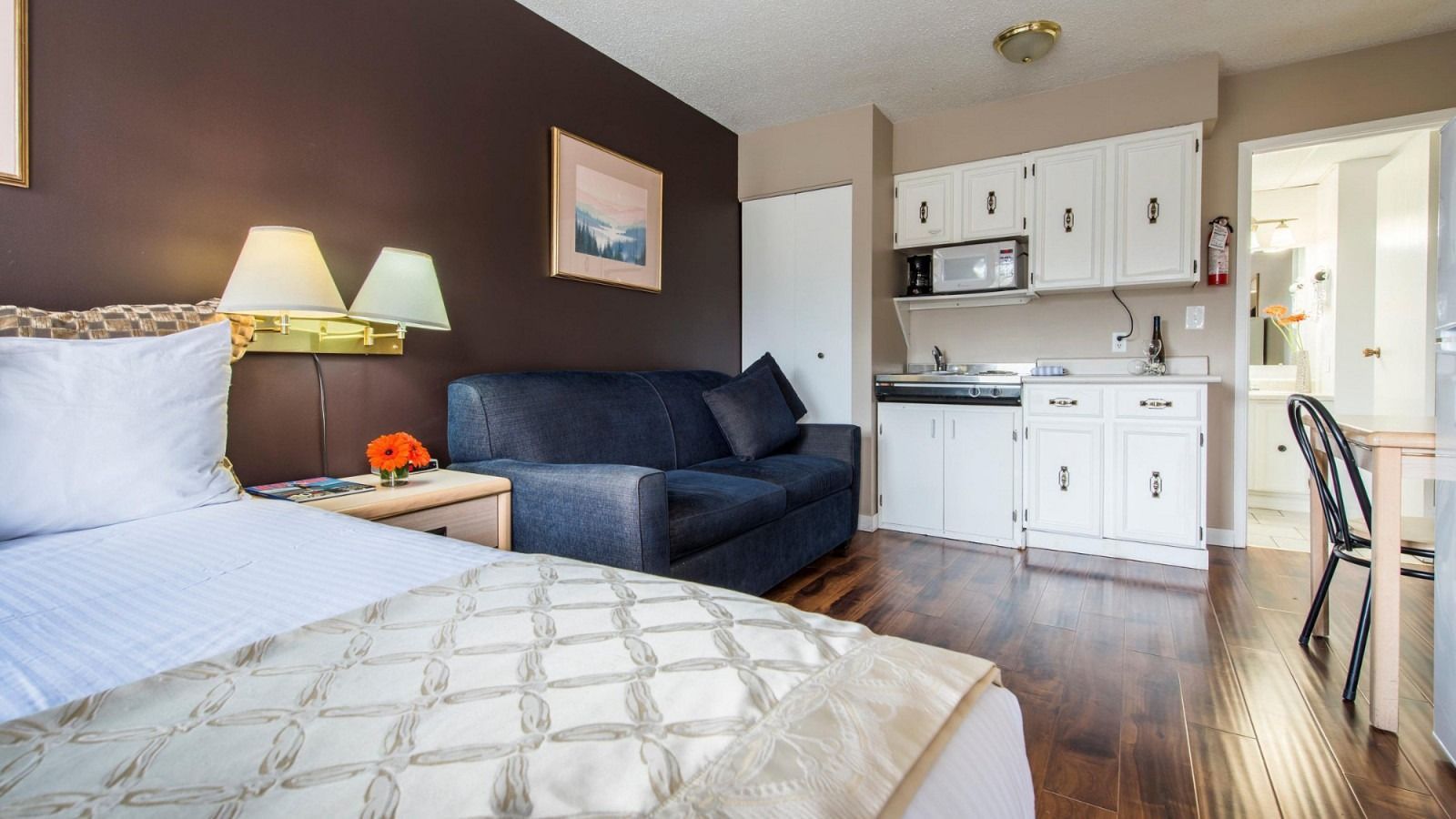 A hotel room with a bed , couch , and kitchen.