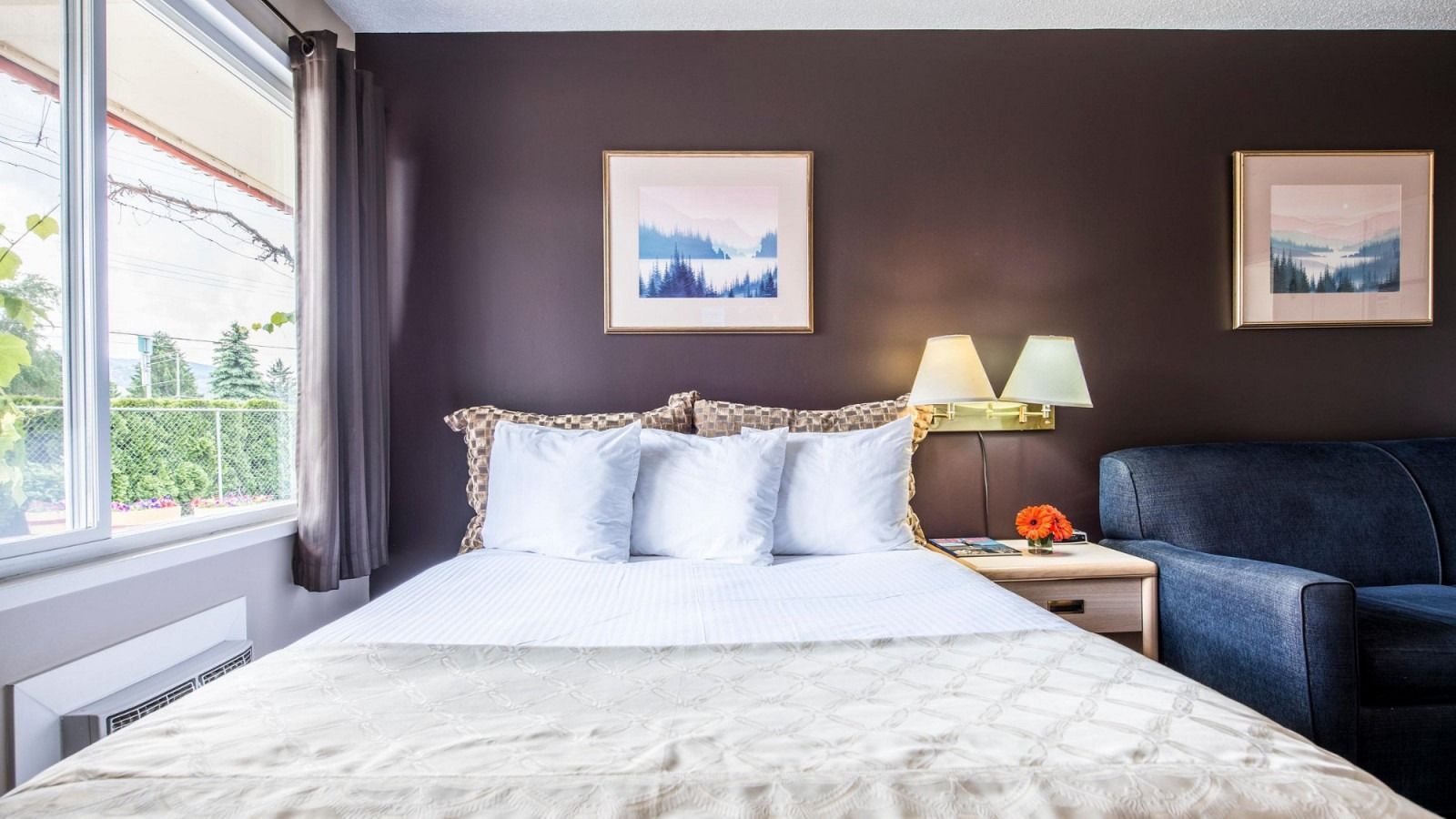 A hotel room with a king size bed and a couch.