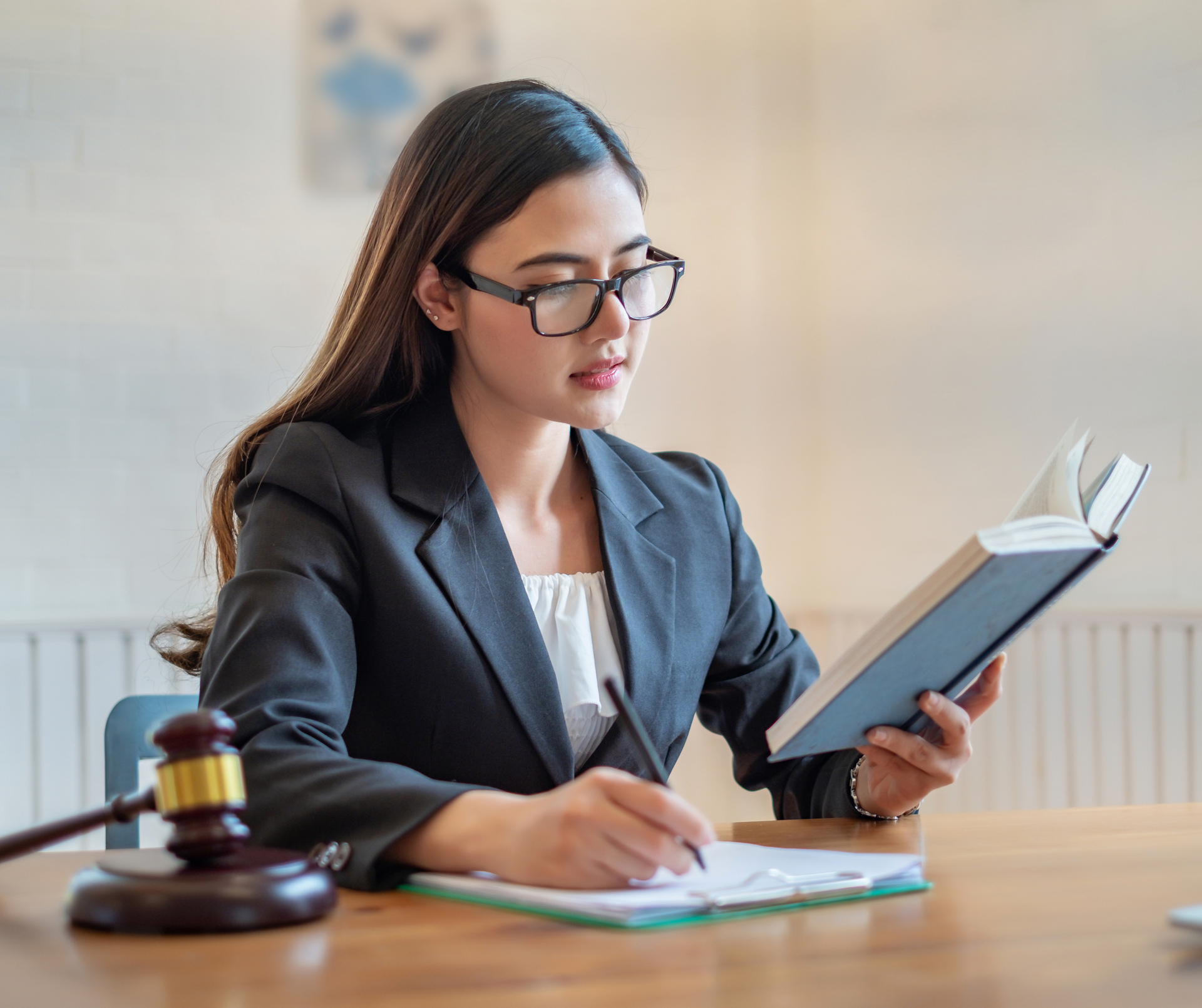 A lawyer reading a book and taking notes, highlighting the importance of delegating tasks to manage 
