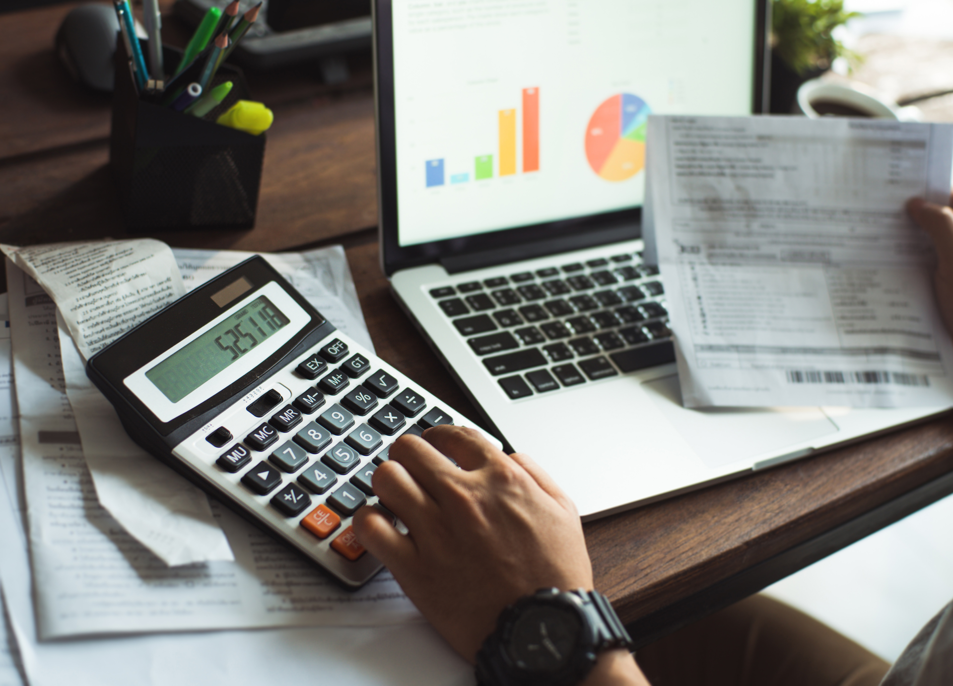 Entrepreneur calculating business expenses with financial reports.