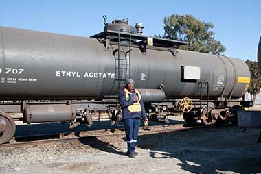 Person stands beside a railcar labeled 