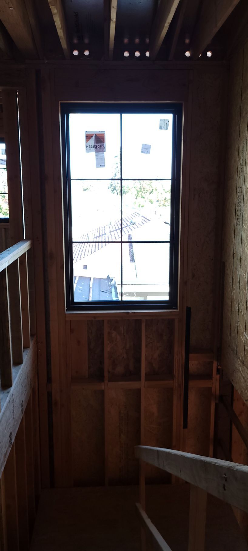 Interior view of a staircase, window at the top. Wooden construction, natural light.