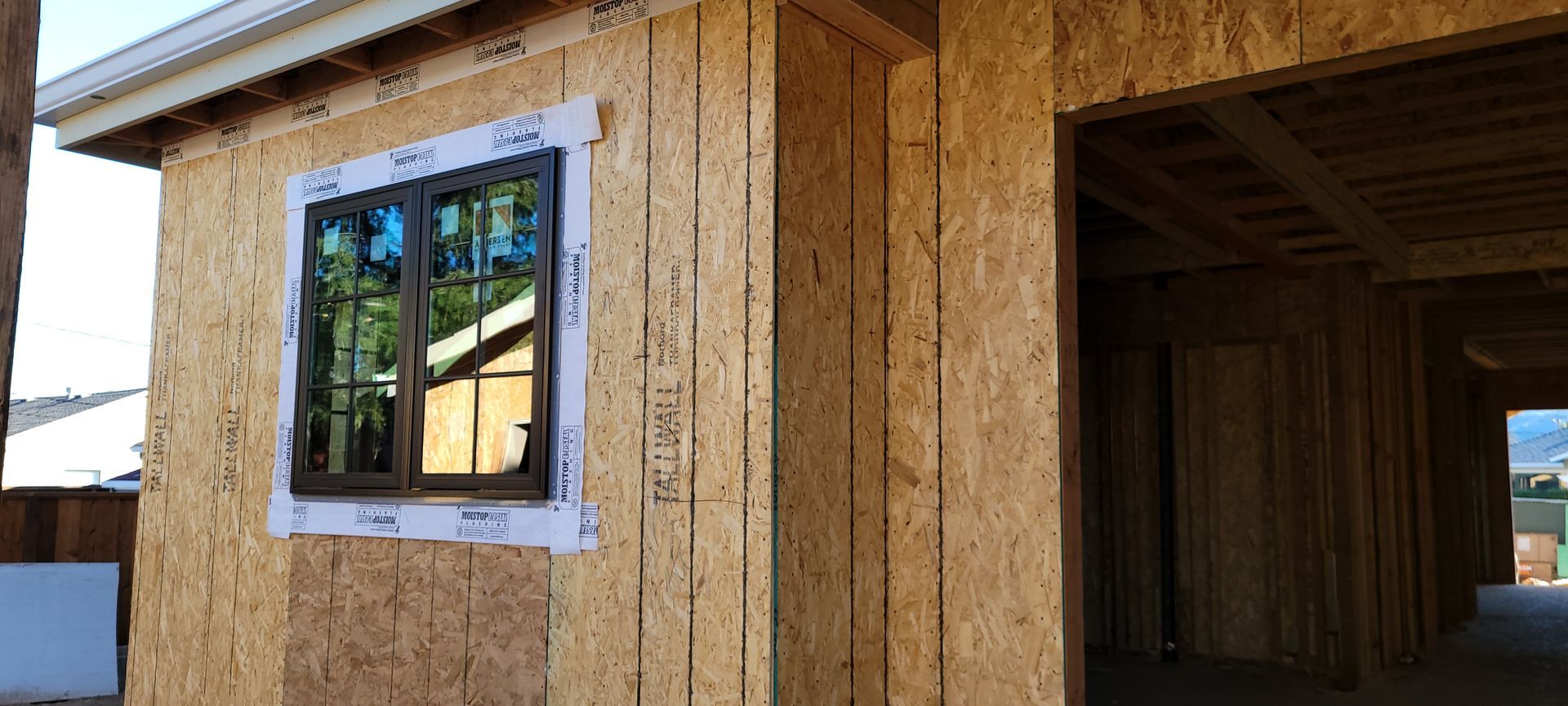 Exterior of a building under construction, showing a window and an open doorway.
