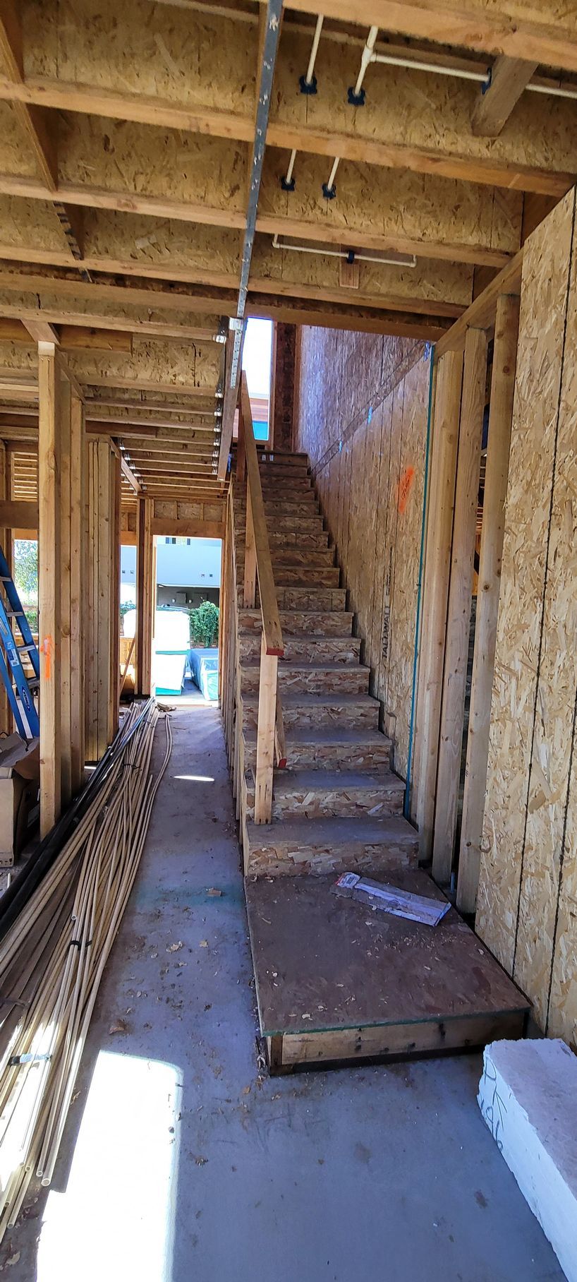 Interior of a building under construction, showing stairs leading to an upper level.