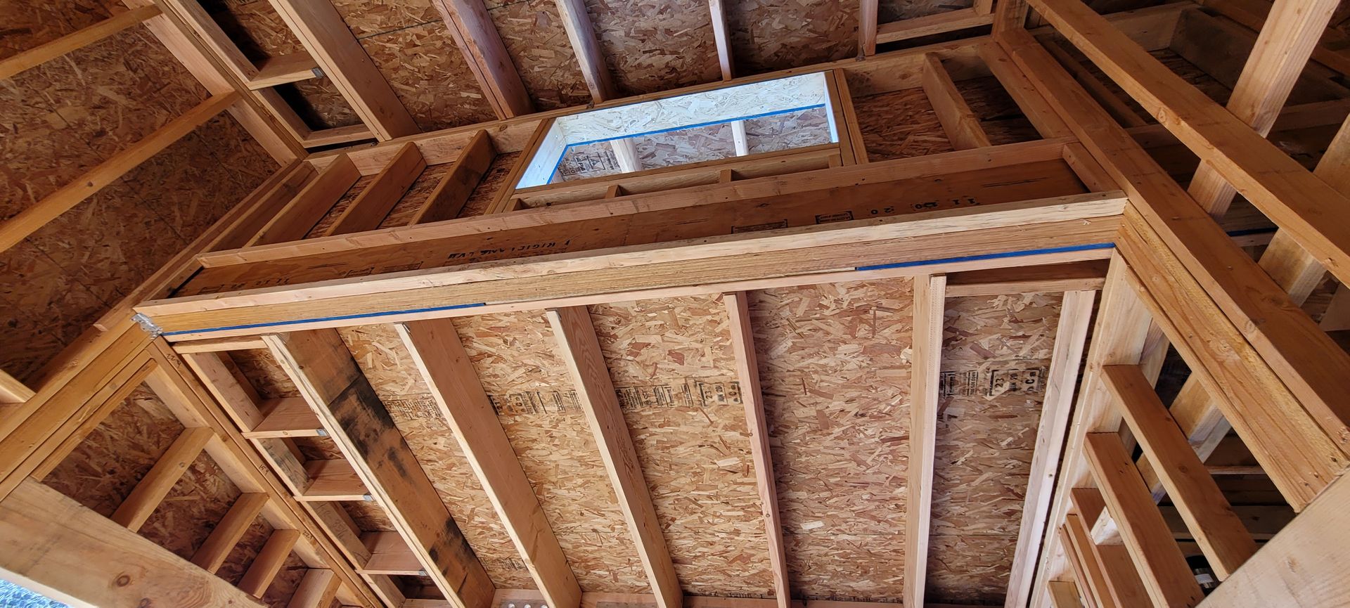 Interior of a building under construction, showing wooden framing for walls and ceiling.