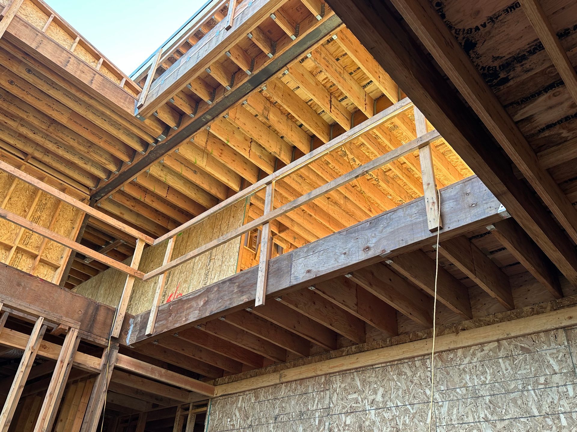 House under construction, exterior view, with sheathing, windows, and roof.
