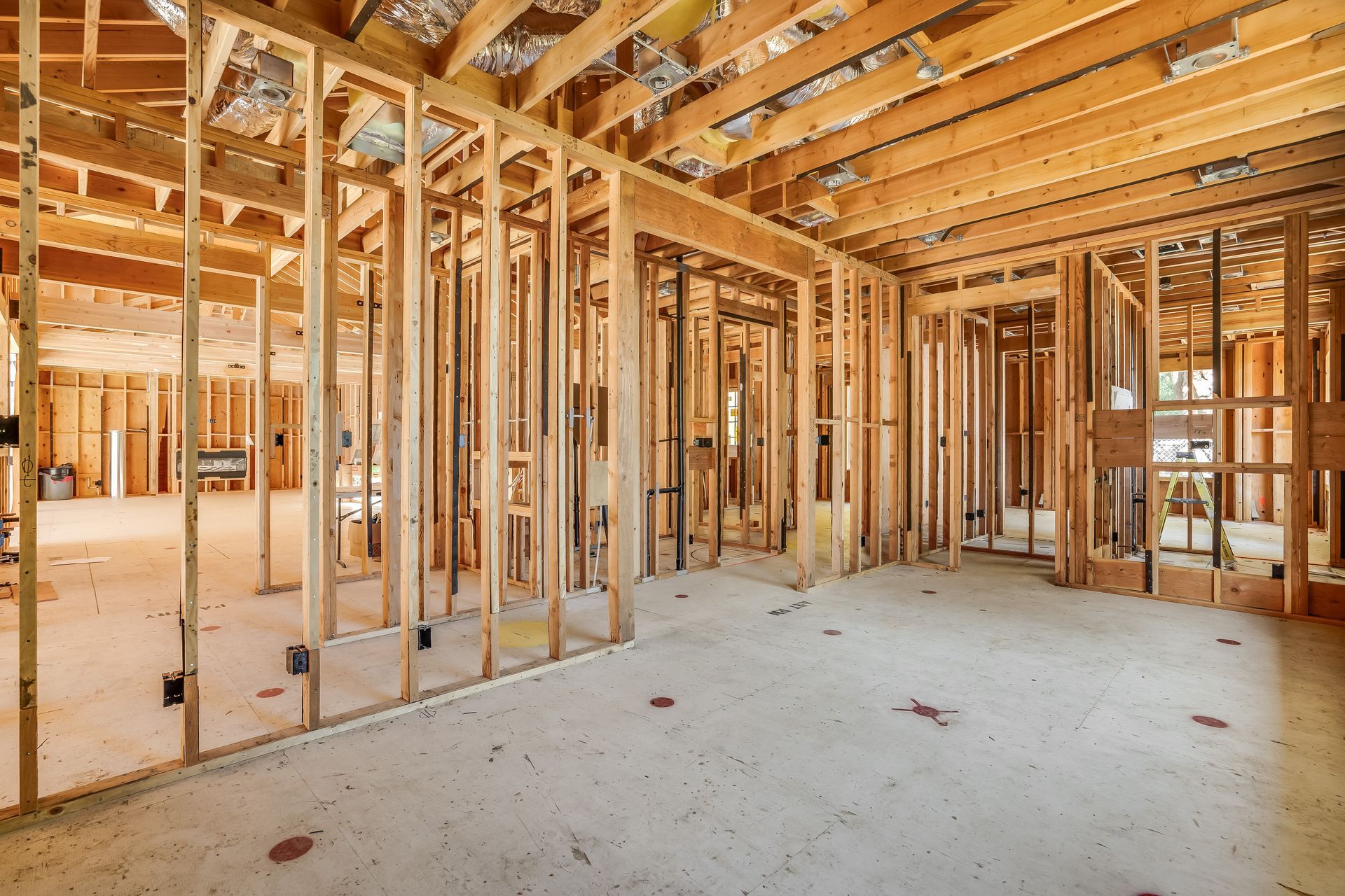 Interior view of a building under construction, showing wooden framing and exposed structure.