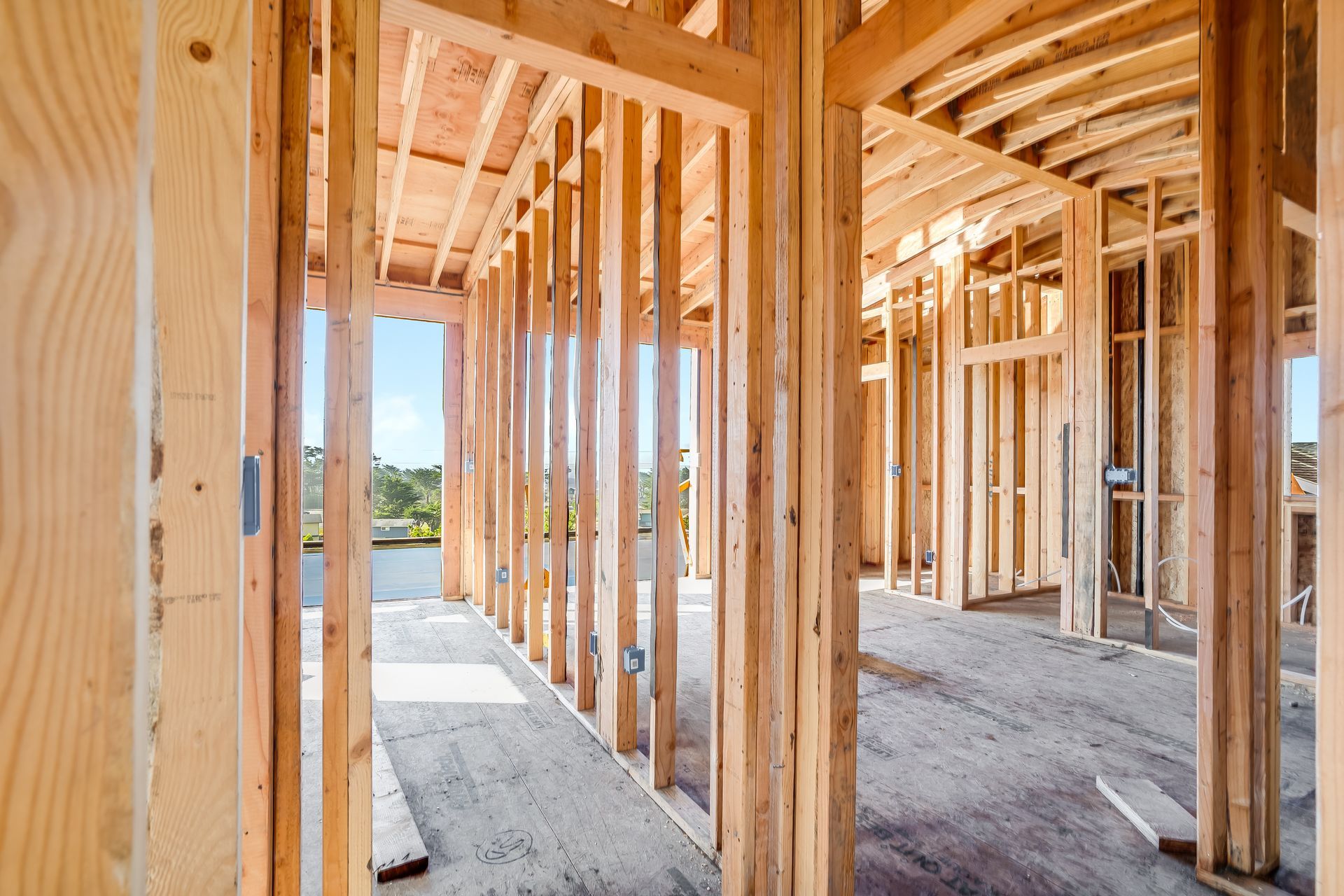 Interior of a building under construction, showing wooden framework of walls and doorways.